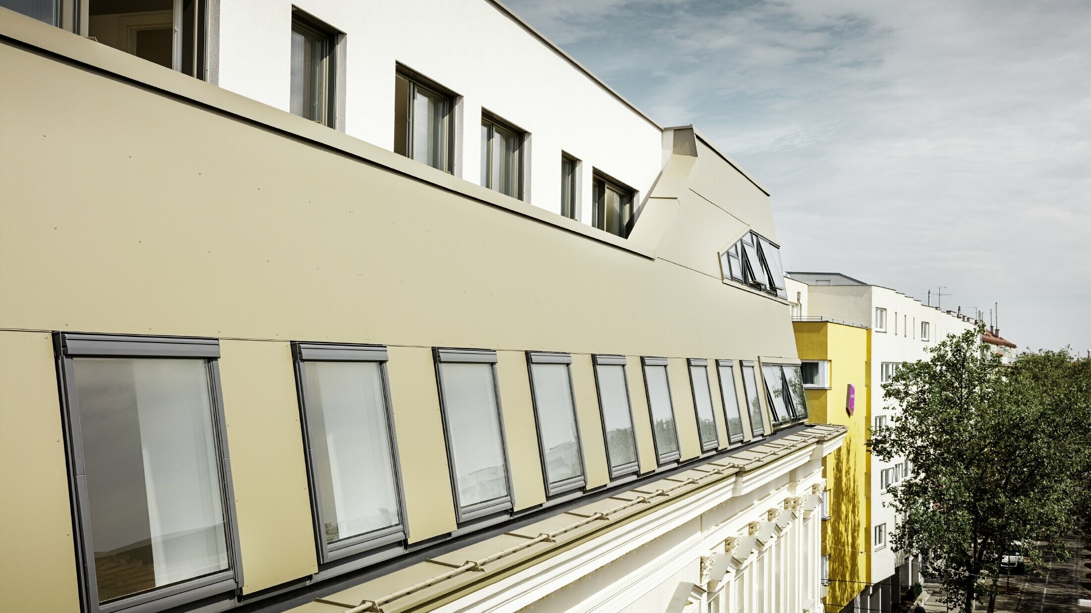 Dakuitbreiding in de Schloßhofer Straße in Wenen met bronskleurige aluminium composietplaten van PREFA