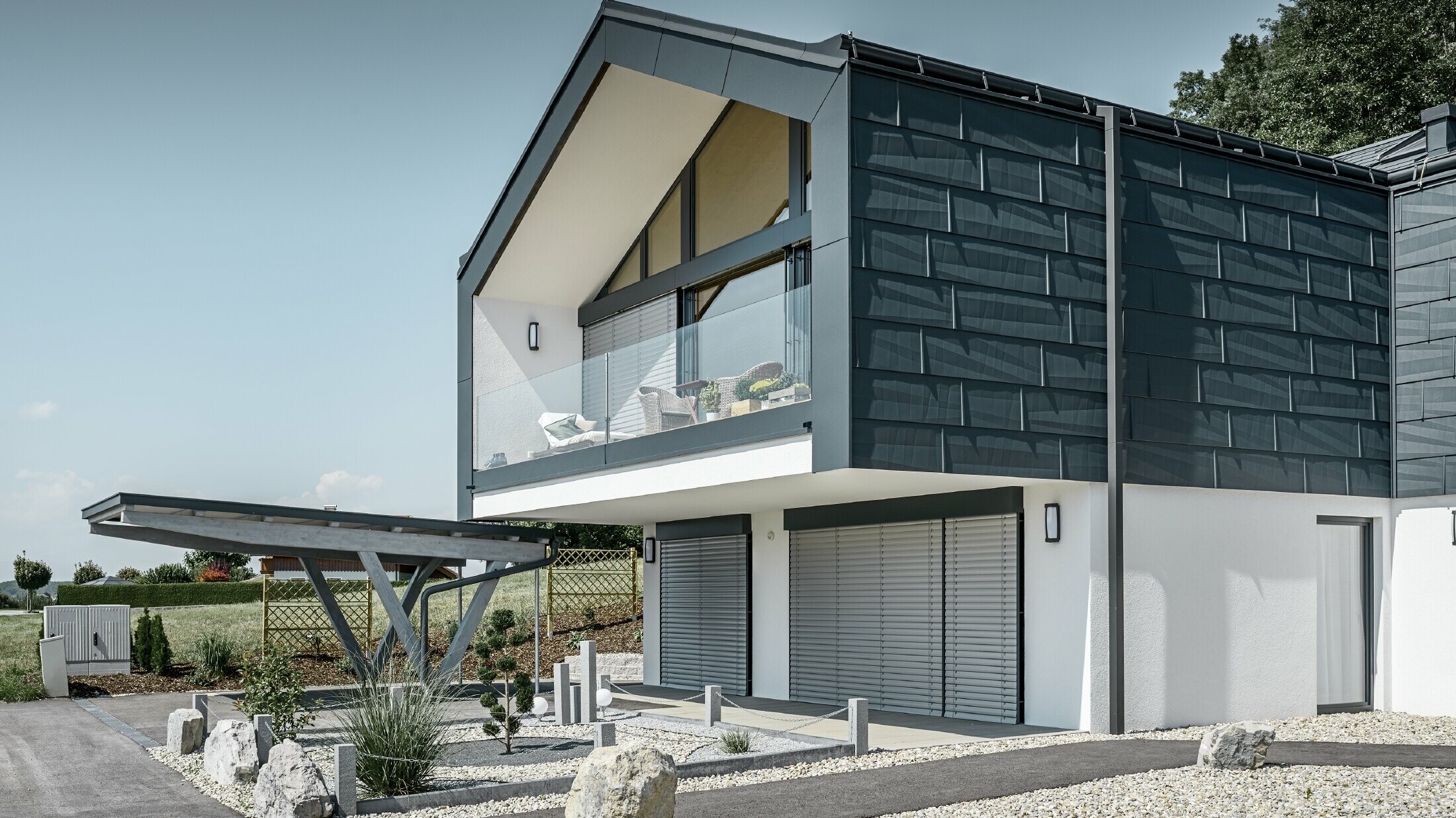 Moderne meergezinswoning met groot raamoppervlak en antracietkleurige FX.12 dak- en gevelpanelen van PREFA