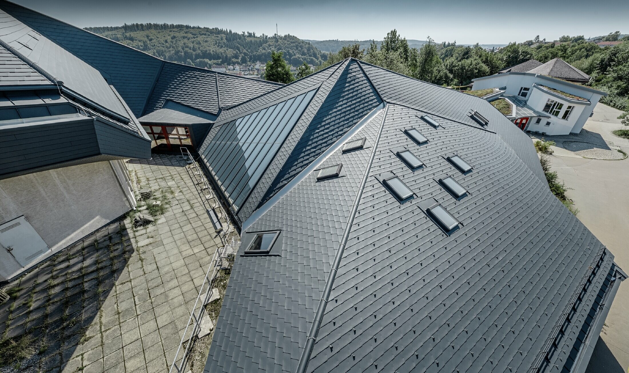 Vrije school in Heidenheim (Duitsland) met groot en onregelmatig dakvlak gerenoveerd met PREFA-dakschindels in antraciet