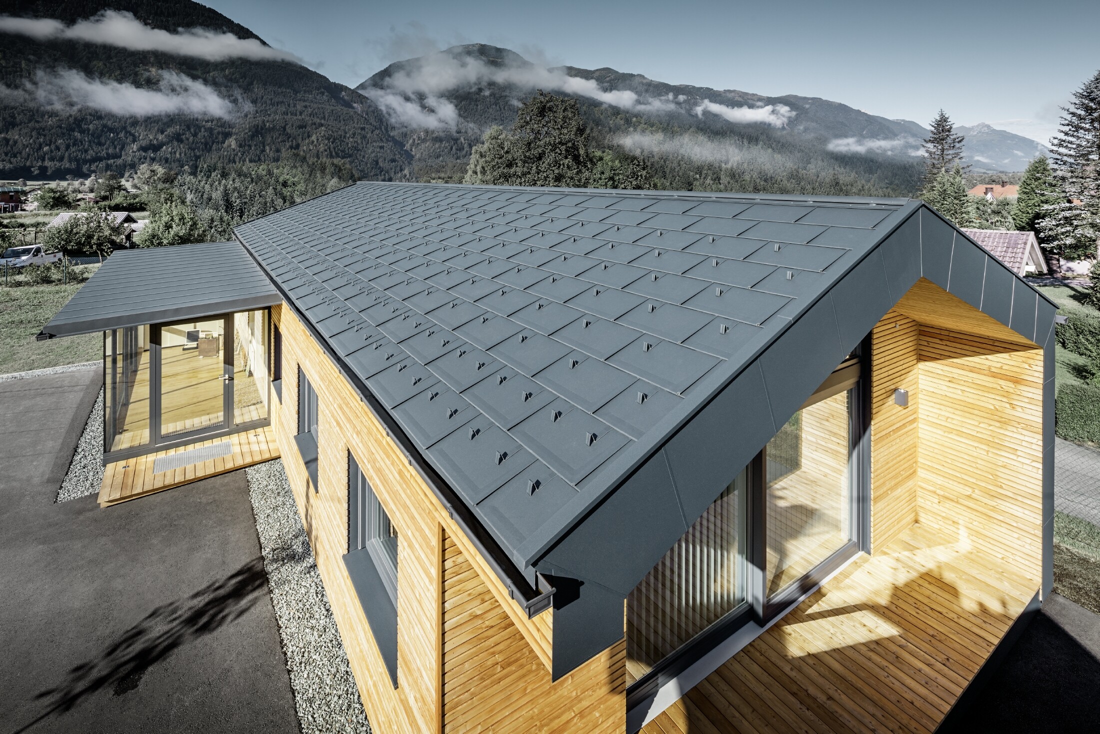 Nieuw kantoorgebouw van Holzbau Faltheiner met gevel van larikshout, royale raampartijen en een PREFA dak in antraciet.