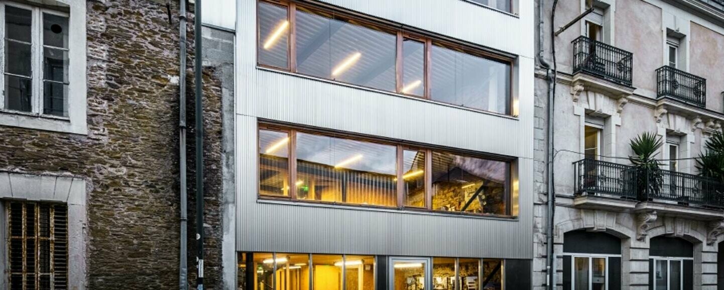 Vue d'ensemble de la rue Marmontel, Nantes, où les bureaux des architectes DLW, dont la façade est bardée de profils triangles, se fond parfaitement. Alliance élégante de l'ancien et du moderne.