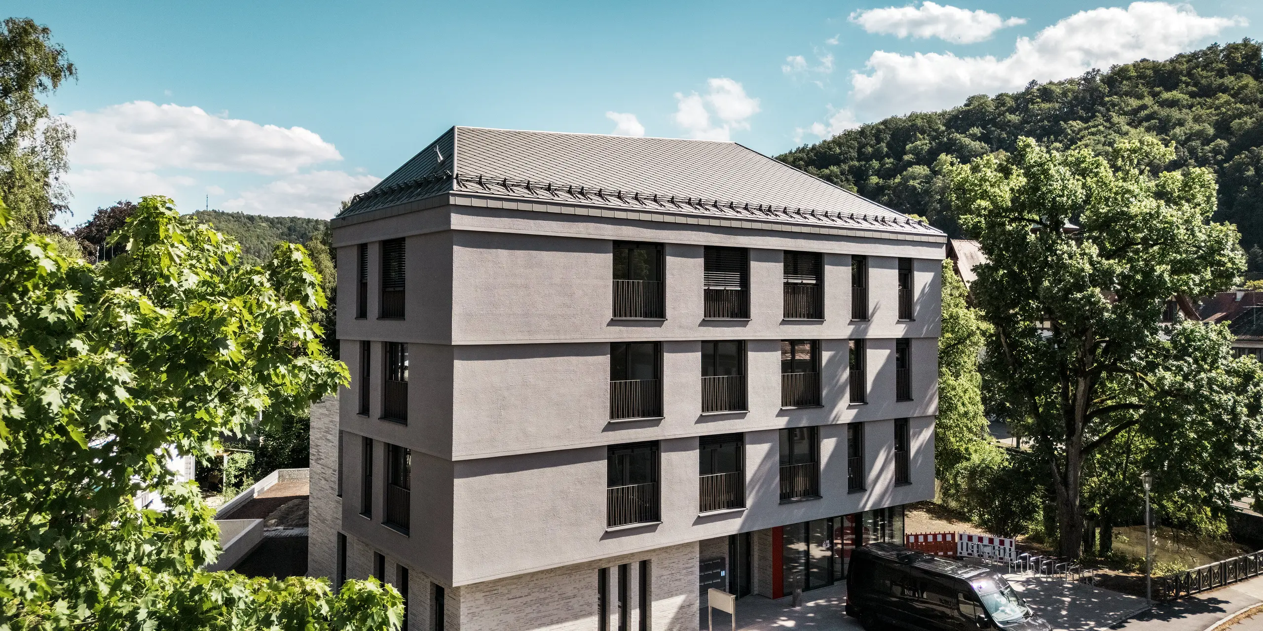 Die Sparkasse Blaubeuren präsentiert sich mit einer klaren, modernen Architektur und einem eleganten Dach aus PREFA Dachrauten 44 × 44 in Bronze. Die präzise Rautenstruktur und das markante Schneefangsystem unterstreichen die harmonische Dachgestaltung. Die leichten, langlebigen und witterungsbeständigen Aluminiumrauten verbinden zeitlose Ästhetik mit zuverlässigem Schutz und hoher Funktionalität.