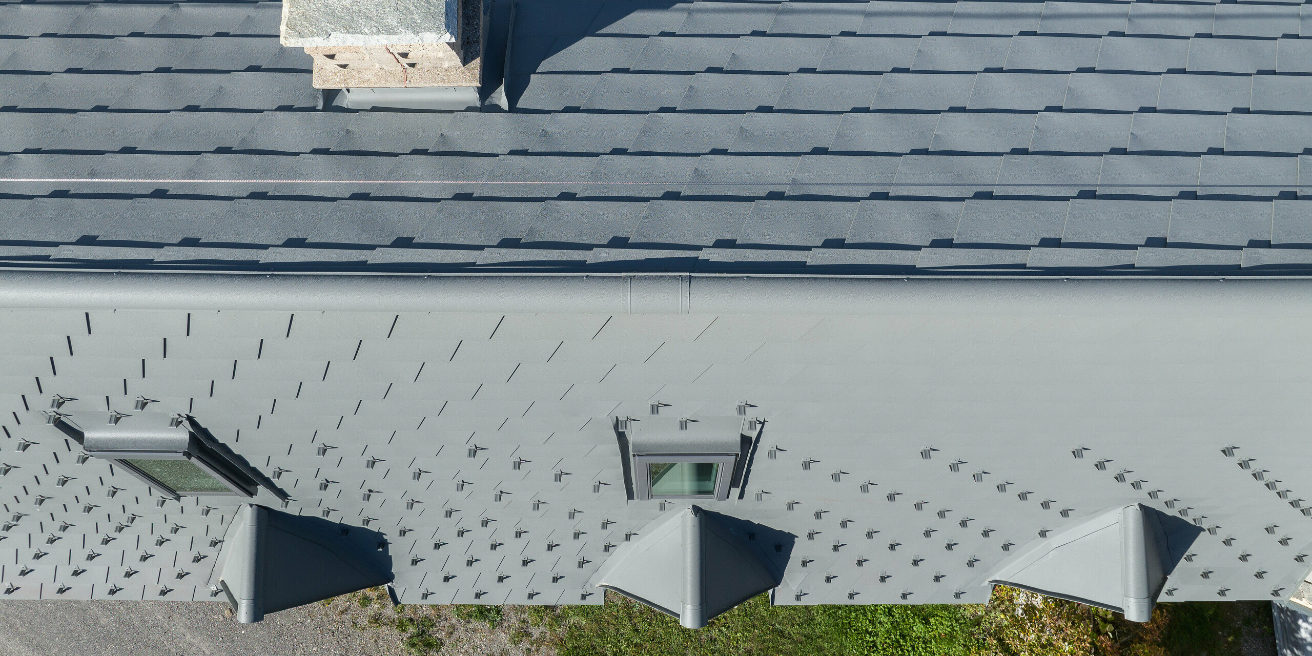 La vaste toiture d'une propriété à Barcelonnette, en France, a été rénovée avec le bardeau de toiture PREFA en P.10 gris souris.
