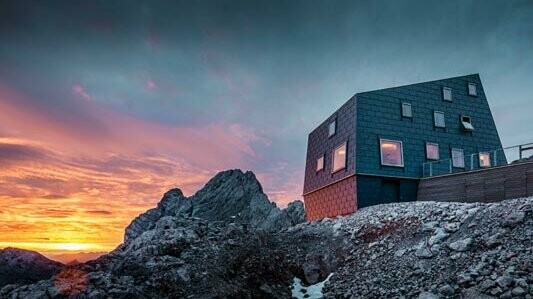 Une architecture hors normes dans les montagnes : le refuge Seethalerhütte sur le Dachstein est recouvert des panneaux de toiture et de façade FX.12 dans la teinte gris pierre.