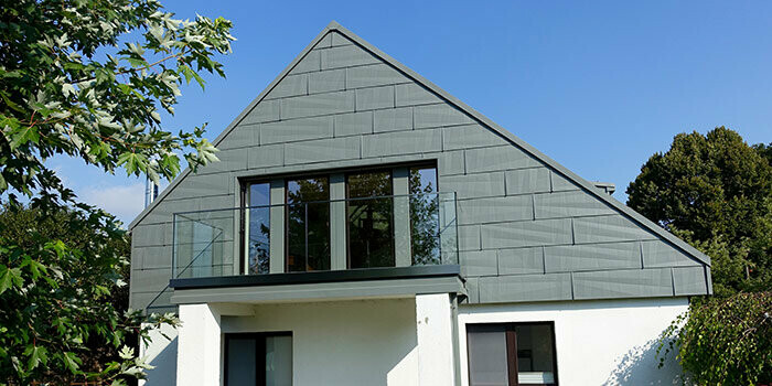 Habillage du pignon d’une façade récemment rénovée à l’aide de panneaux de façade FX.12 PREFA couleur gris souris.