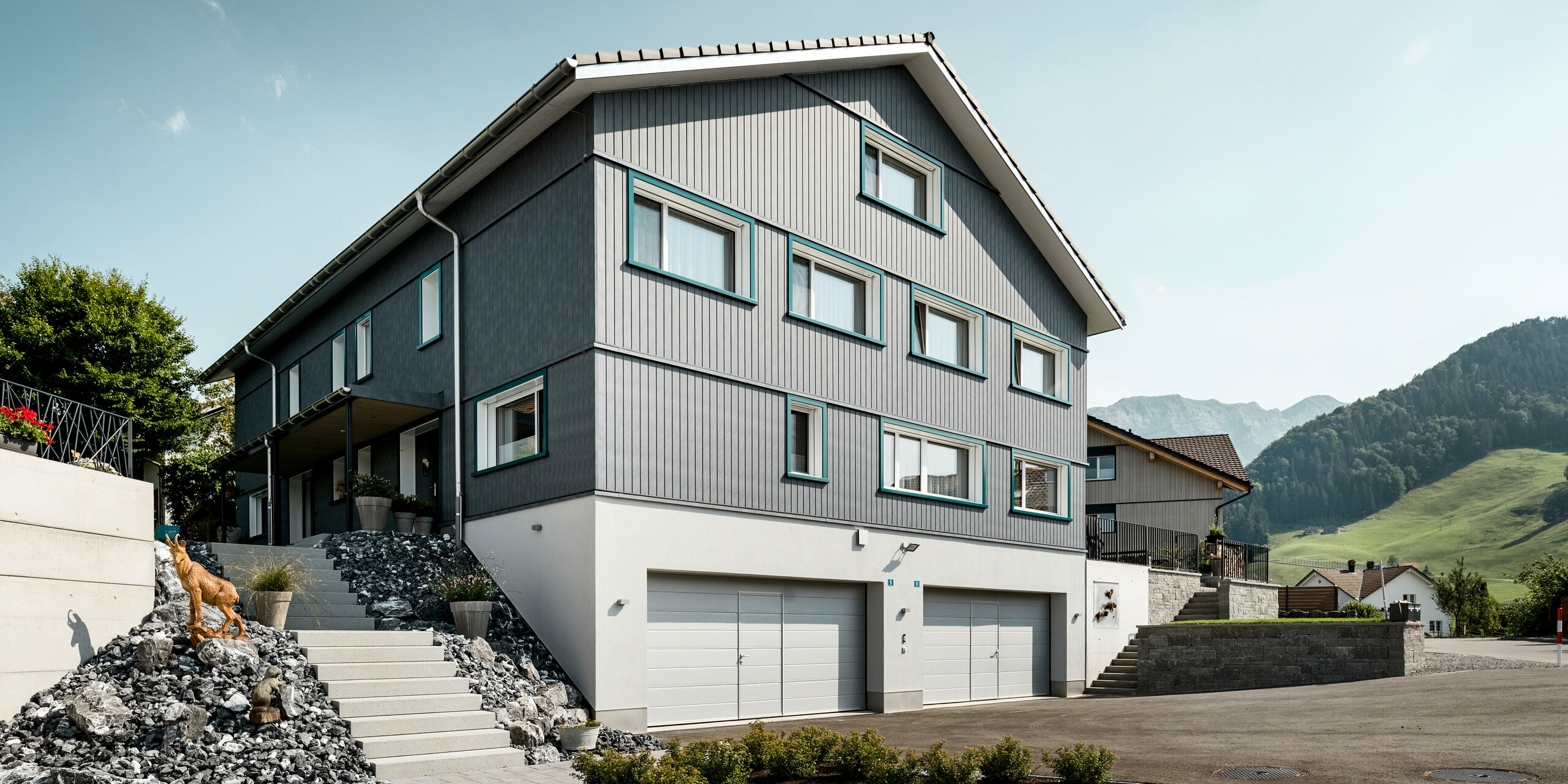 Sidings PREFA en gris pierre P.10 et blanc Prefa P.10 sur les façades de deux immeubles d'habitation voisins à Weissbad, en Suisse.