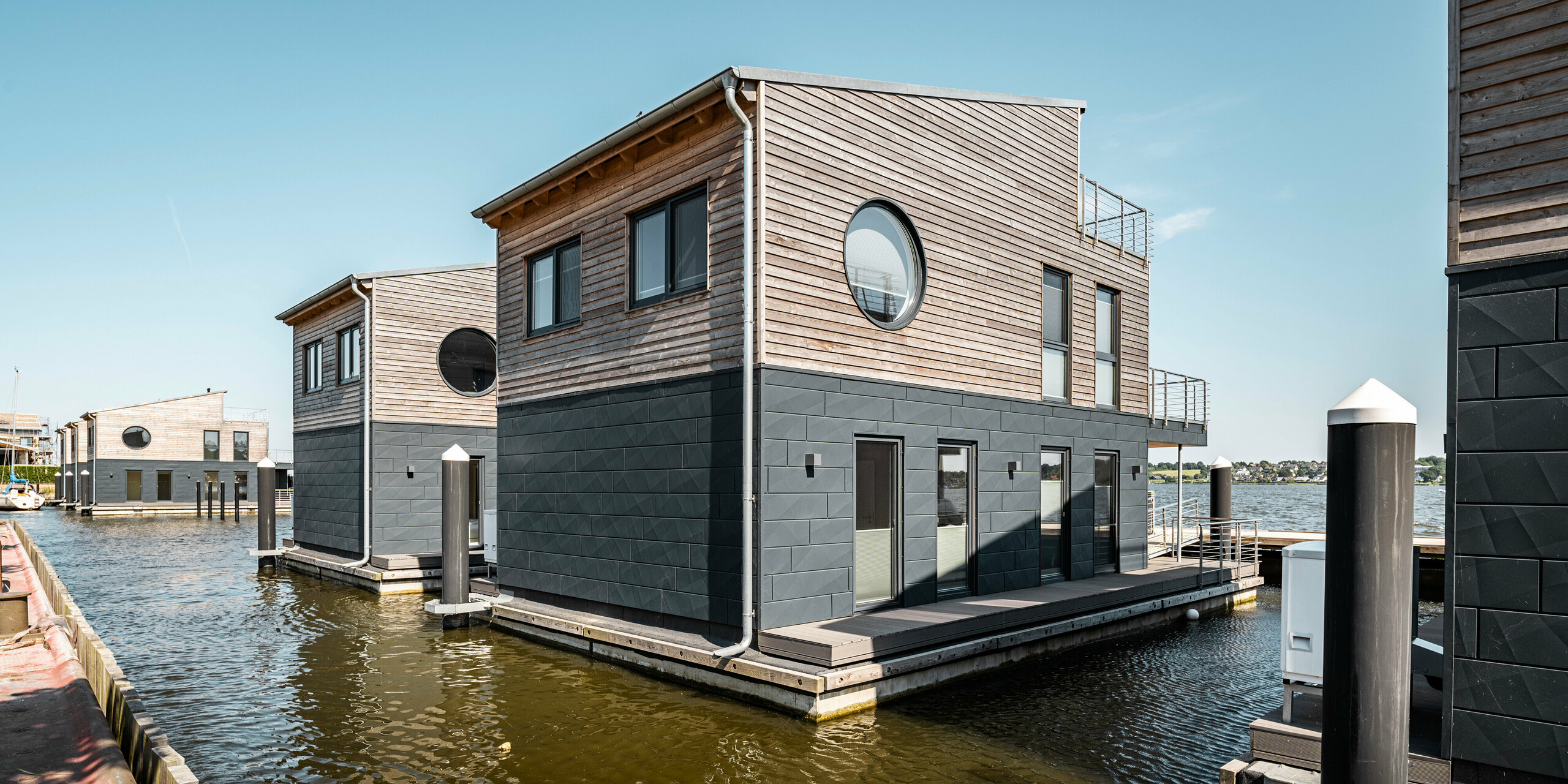 La façade en aluminium Siding.X PREFA  entoure onze maisons flottantes dans le port pionnier du Schleswig.
