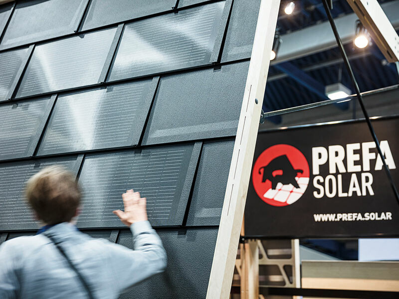 PREFA Messestand in Wels mit einer Wand zur Ausstellung der PREFA Solardachplatte.