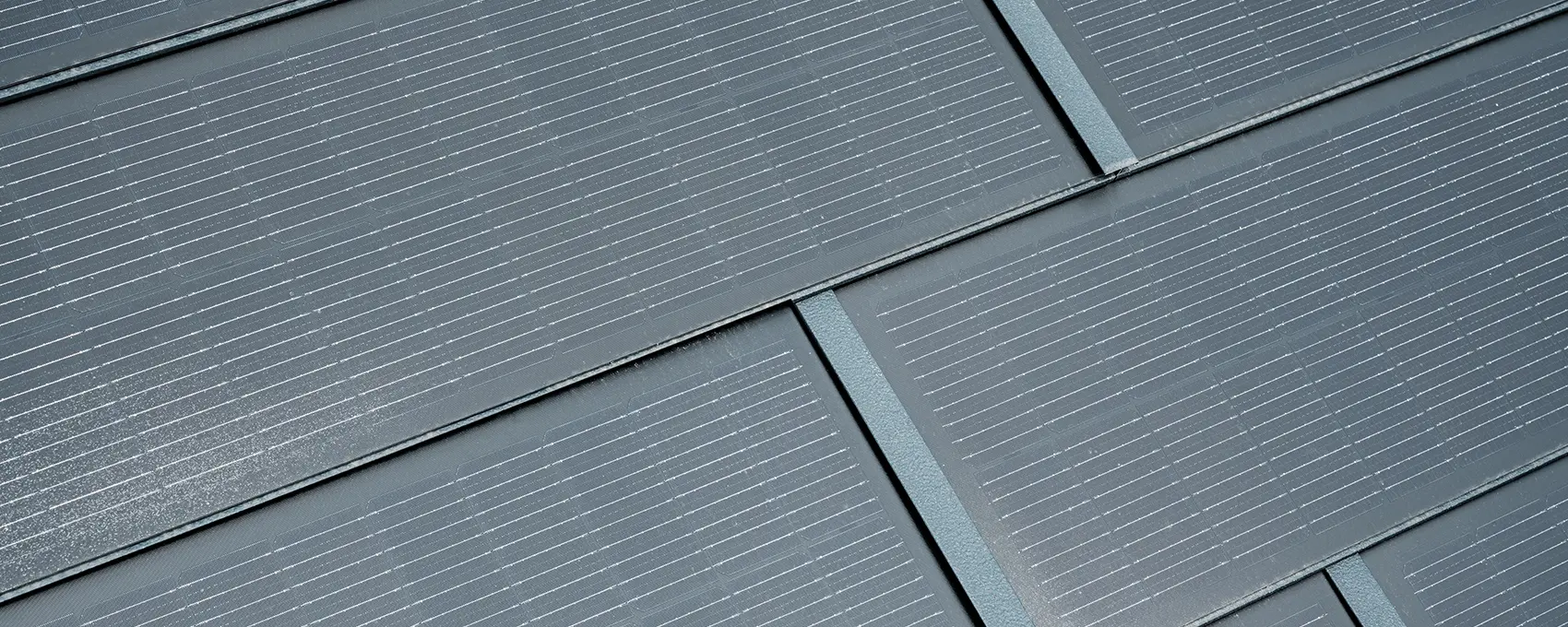 Detailfoto van de geplaatste kleine solar-dakpannen. De kleine solar-dakpan in de kleur P.10 antraciet werd gecombineerd met dakpan R.16. 
