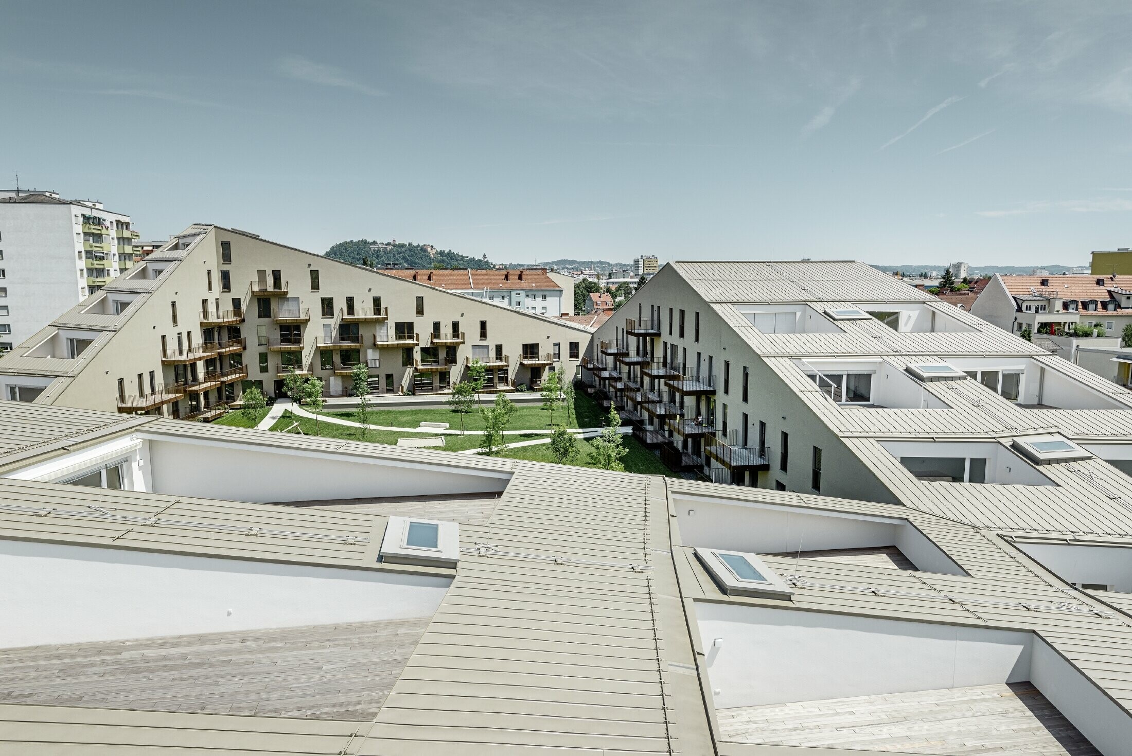 Complexe résidentiel à la silhouette élancée et à la toiture plane avec terrasses intégrées et grandes baies vitrées — Toiture Prefalz bronze métallisé (couleur spéciale)