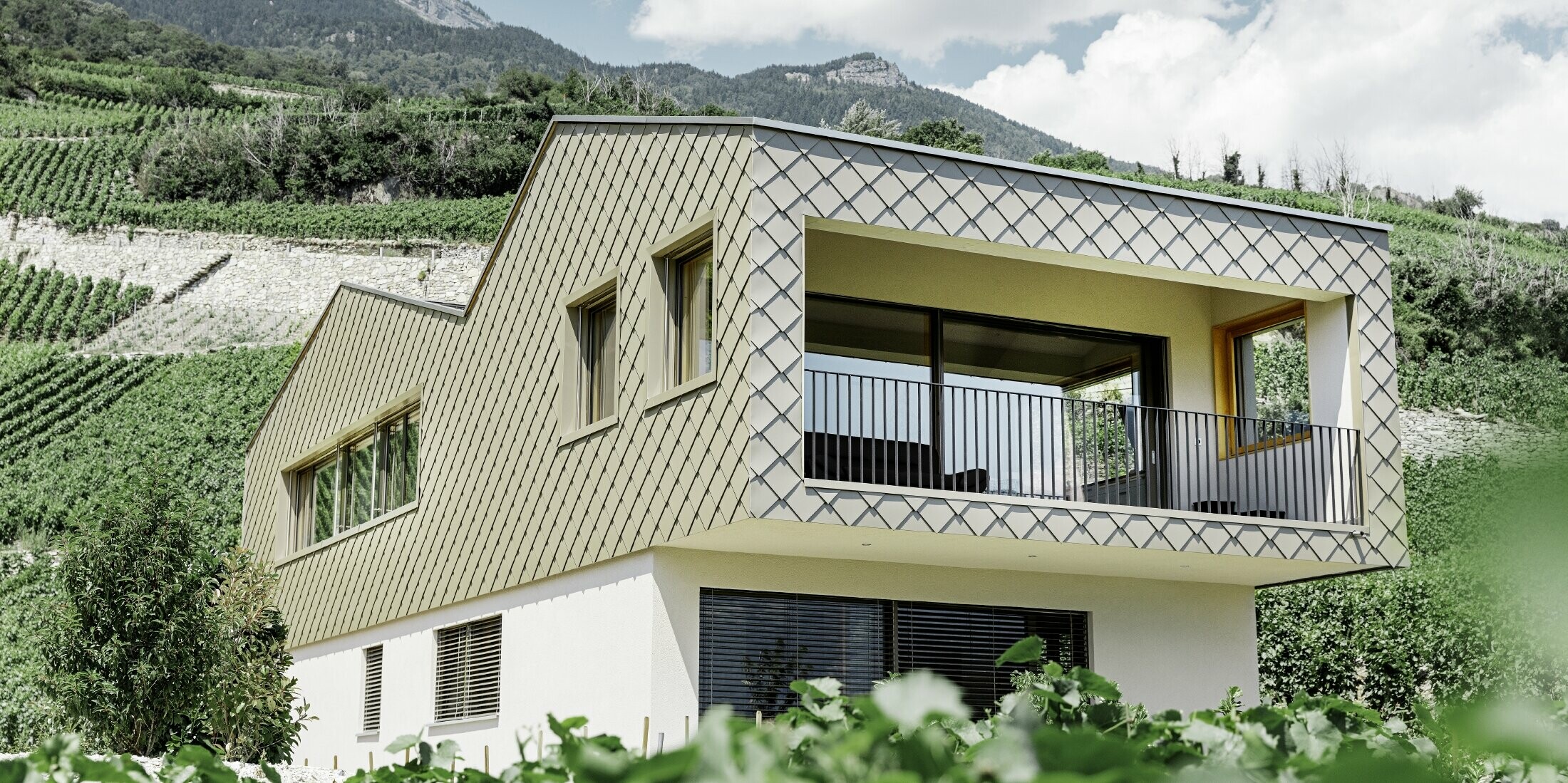 modernes Einfamilienhaus mitten in den Weinbergen des Rhônetals mit 4 unterschiedlichen Dachflächen und offener Galerie mit einer Rautenfassade in bronze