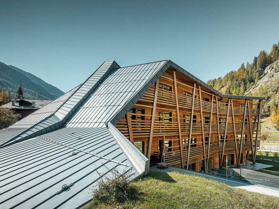 Luxus-Öko-Hotel Au Charmant Petit Lac in Champluc mit einem PREFALZ-Dach in P.10 Steingrau und einer Holzfassade.