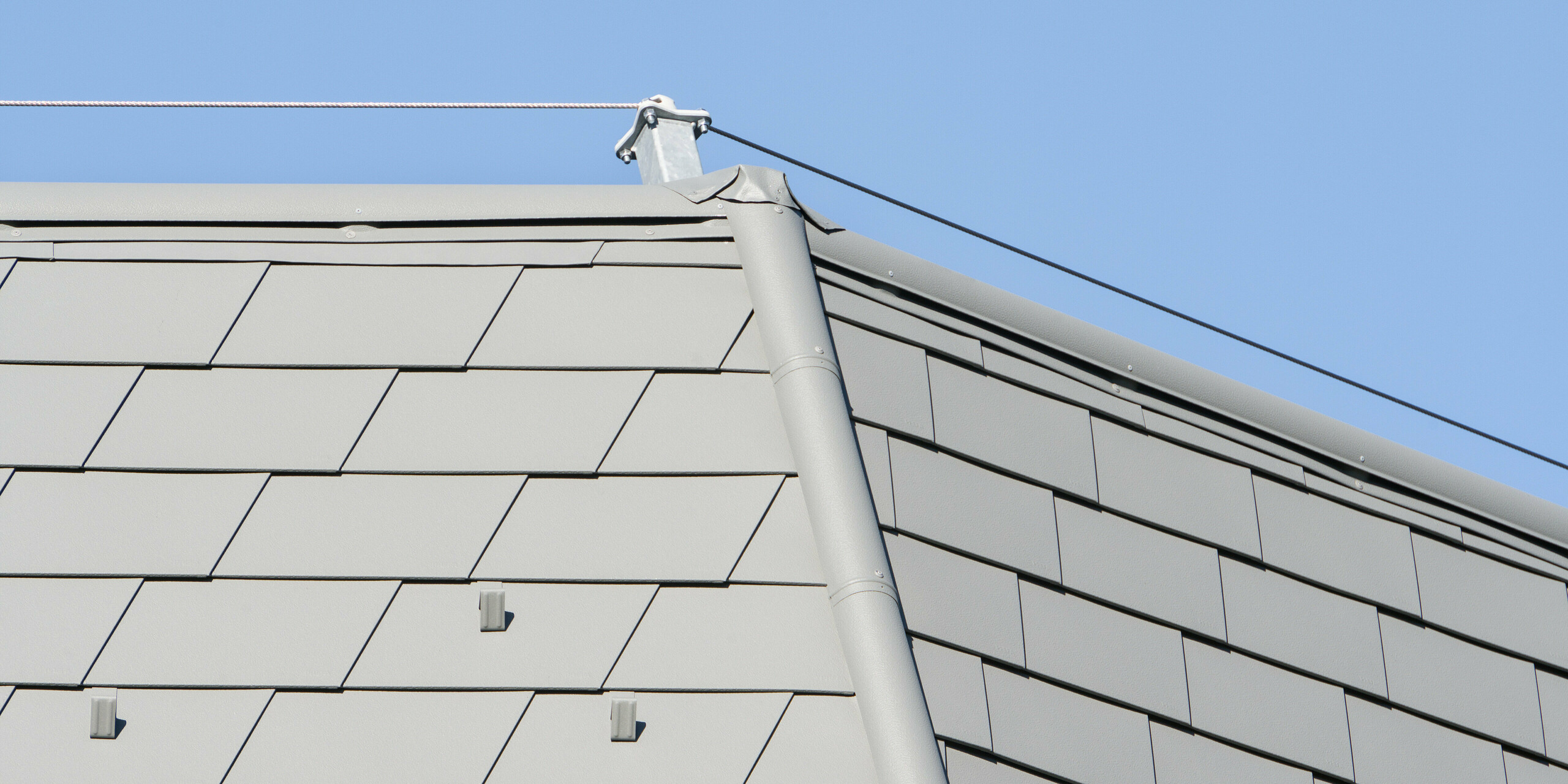 Detailansicht der PREFA Dachschindeln in P.10 Hellgrau bei einem aufwendigen Sanierungsprojekt in Barcelonnette, Frankreich.
