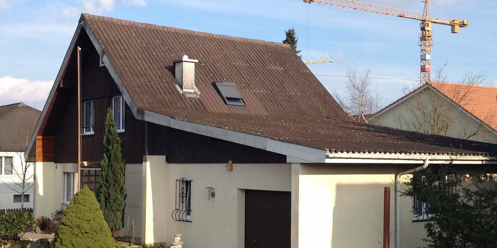 Maison avant la rénovation de toiture à l’aide de tuiles PREFA, toit à deux pans et garage