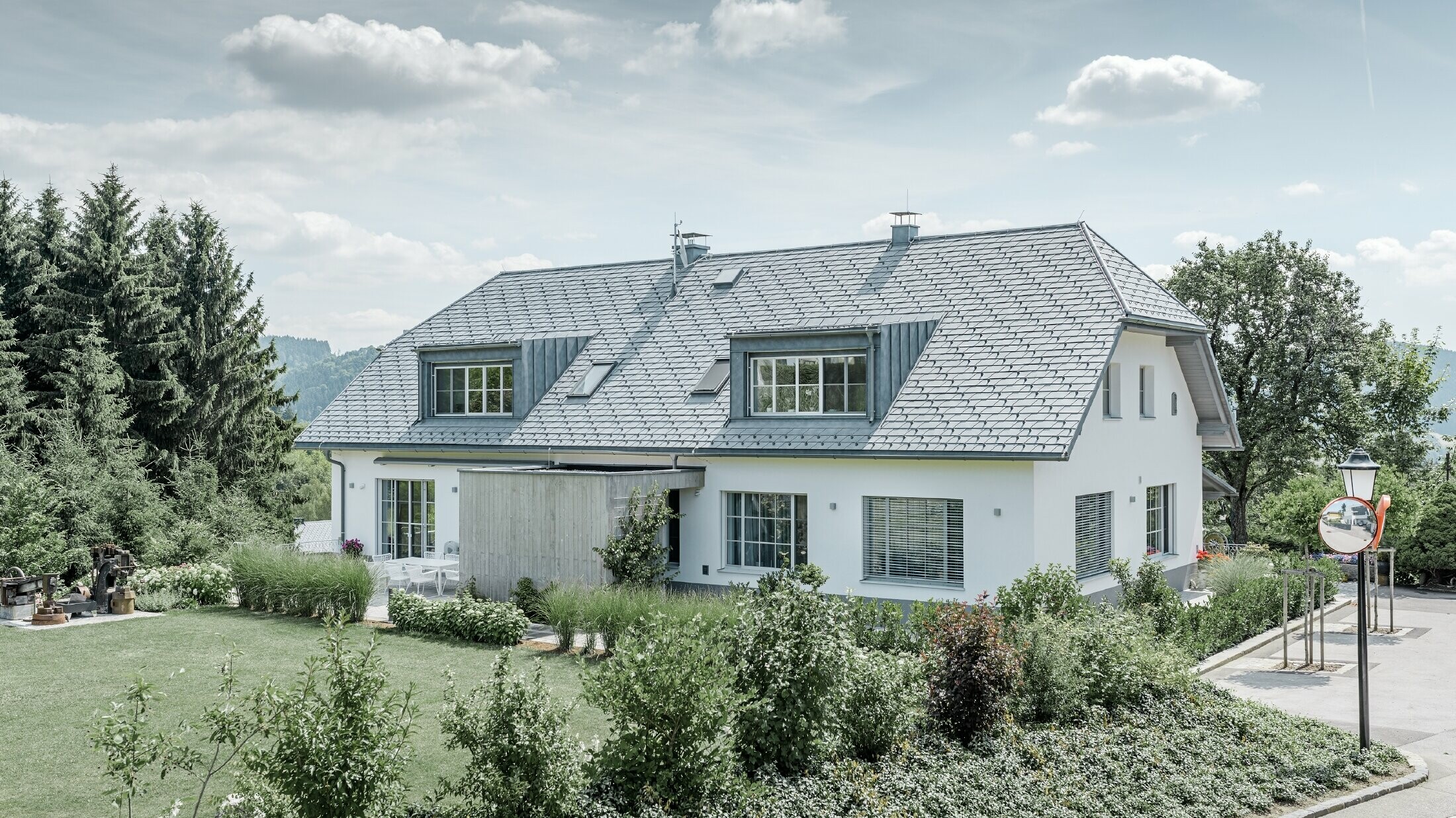 Dakrenovatie van een schilddak met de lichte PREFA dakschindel in steengrijs met twee dakkapellen.