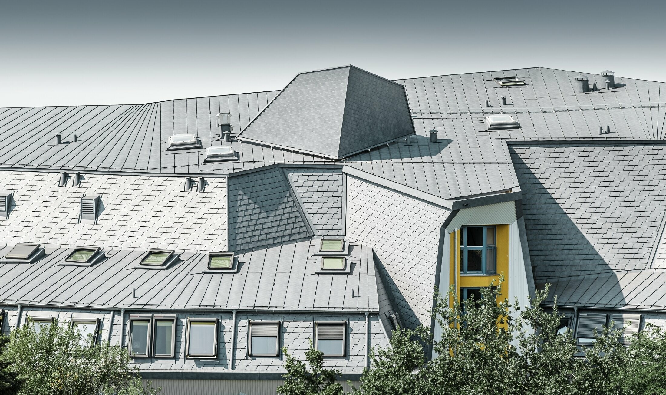 Ingenieus geconstrueerd daklandschap met dakramen en diverse hoeken bij het Haus Aja-Textor-Goethe, gedekt met de PREFA dakschindel en Prefalz in steengrijs
