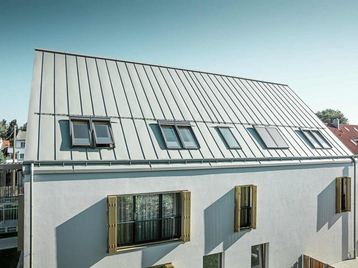 Vue surélevée du foyer d'Augsburg, on aperçoit la toiture en PREFALZ dans la teinte gris de zinc baignée par le soleil