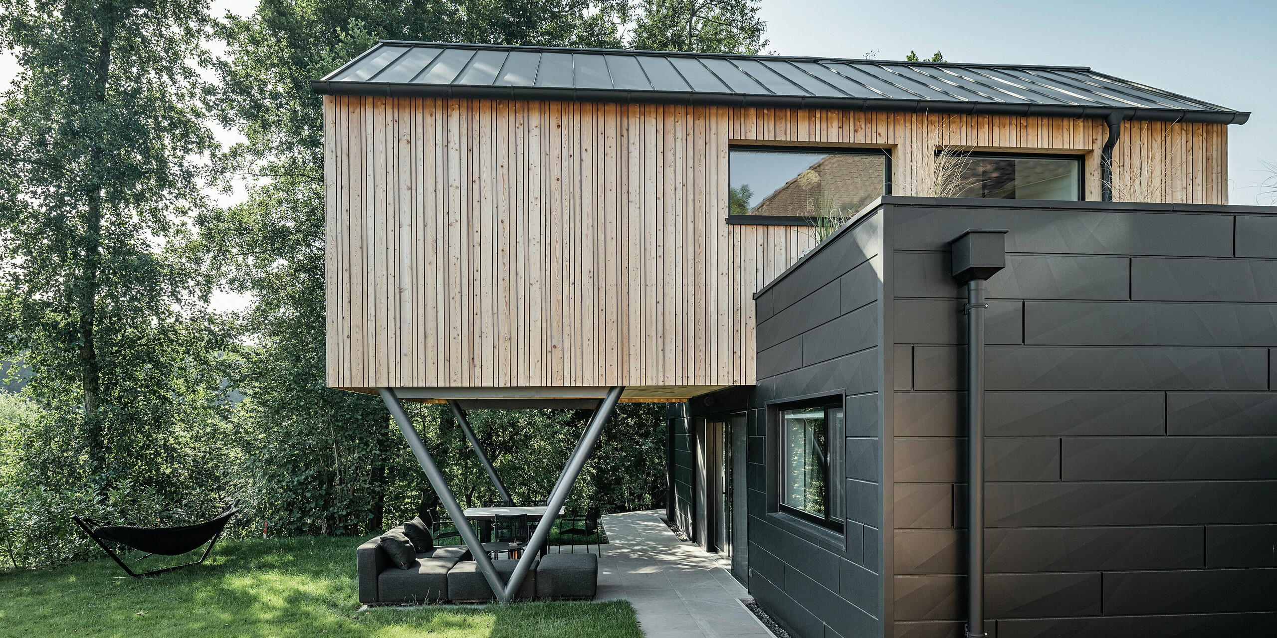 Seitenansicht auf Chalet 5 mit PREFALZ Satteldach sowie Holz- und PREFA Aluminiumfassade aus Siding.X