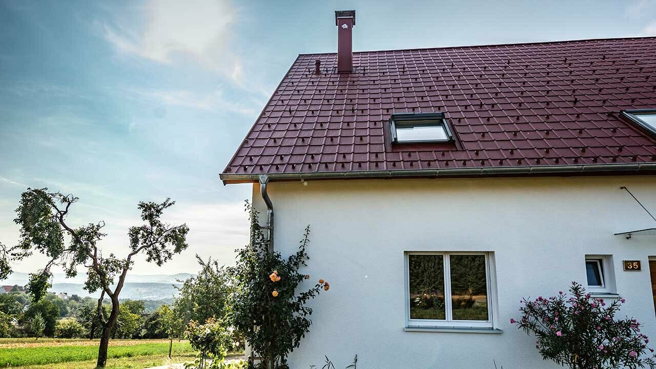 Maisonnette à la campagne, toiture rénovée avec tuile PREFA couleur rouge oxyde, fenêtres de toit et abergement de cheminée.