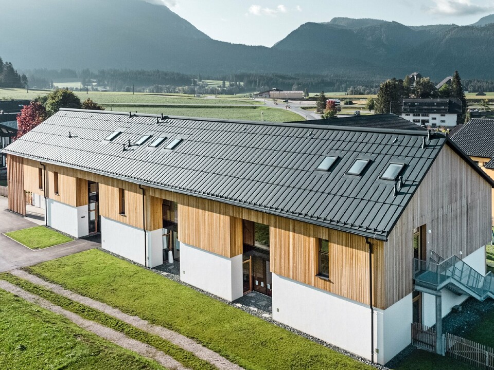 Kruidenkleuterschool in Bad Mitterndorf met groot PREFALZ dak in P.10 antraciet en houten gevel