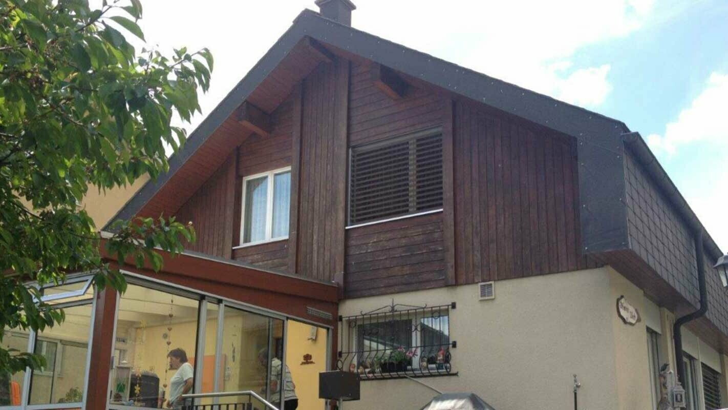 Haus vor der Fassadensanierung mit PREFA Sidings in Holzoptik, Giebel ist aktuell mit abgewittertem Holz verkleidet