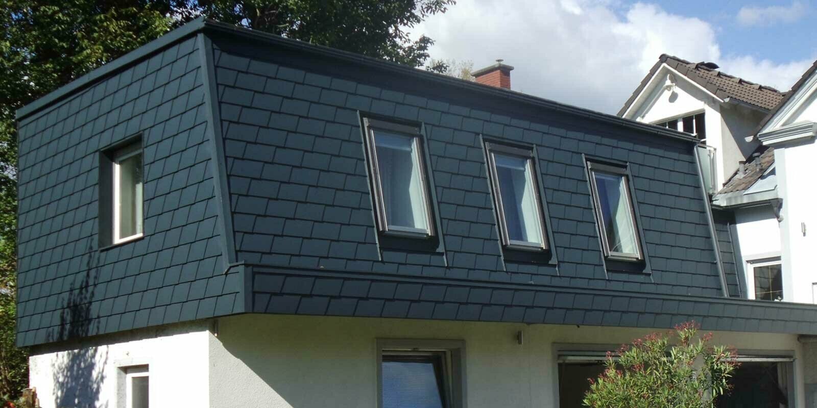 Aménagement de toit à l’aide de bardeaux de toiture PREFA, ajout d’une nouvelle structure moderne couleur anthracite, nombreuses fenêtres