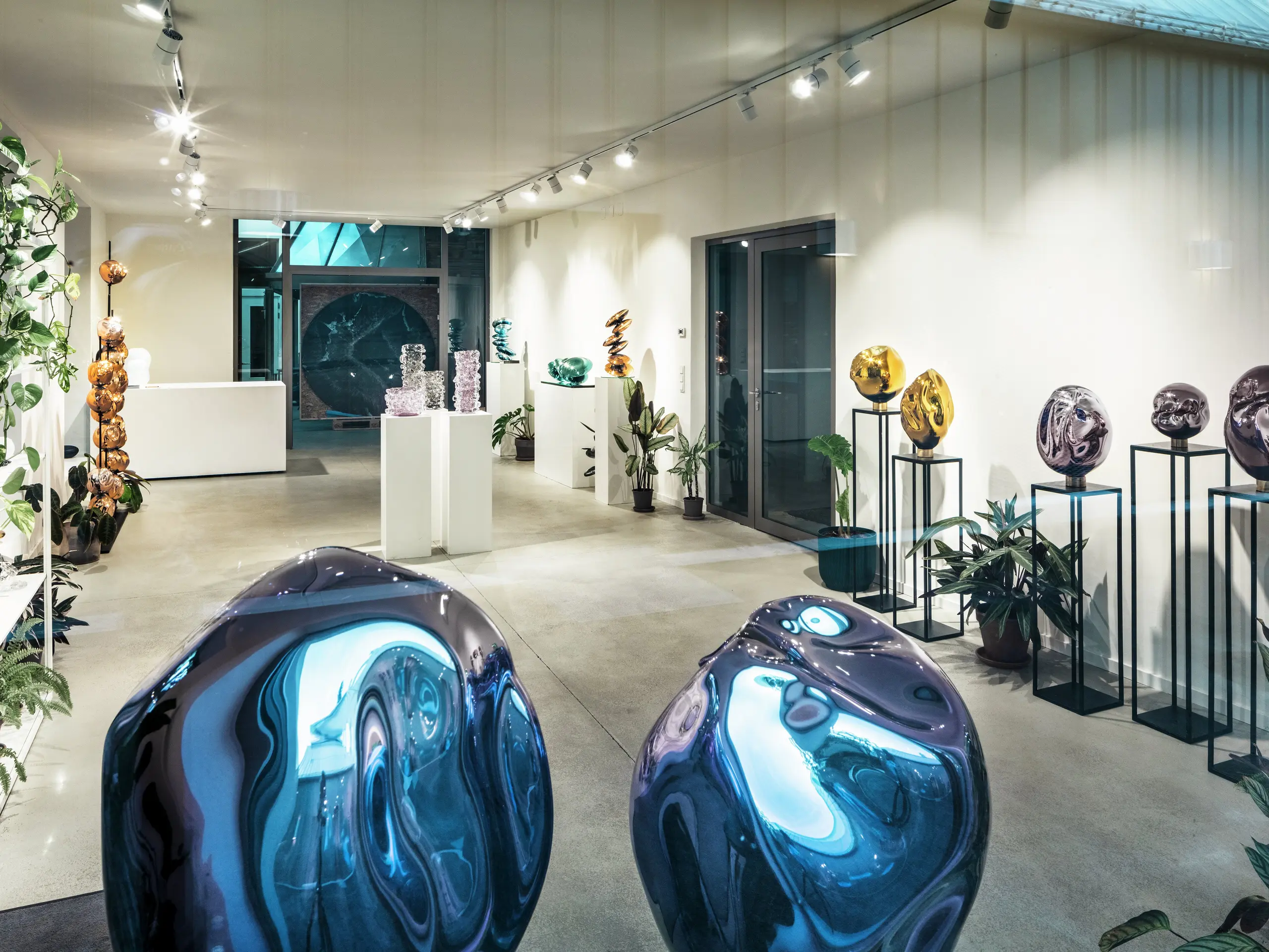 Ein Blick ins Innere des Studio Comploj in Wien mit einer Ausstellung handgefertigter Glasobjekte. Der moderne Galerieraum vereint Kunst, Design und Handwerkskunst in einem eleganten Ambiente.