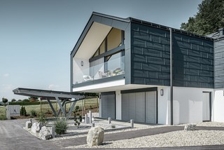 Maison en copropriété avec large façade vitrée — Toiture et façade réalisées avec des panneaux FX.12 PREFA couleur anthracite