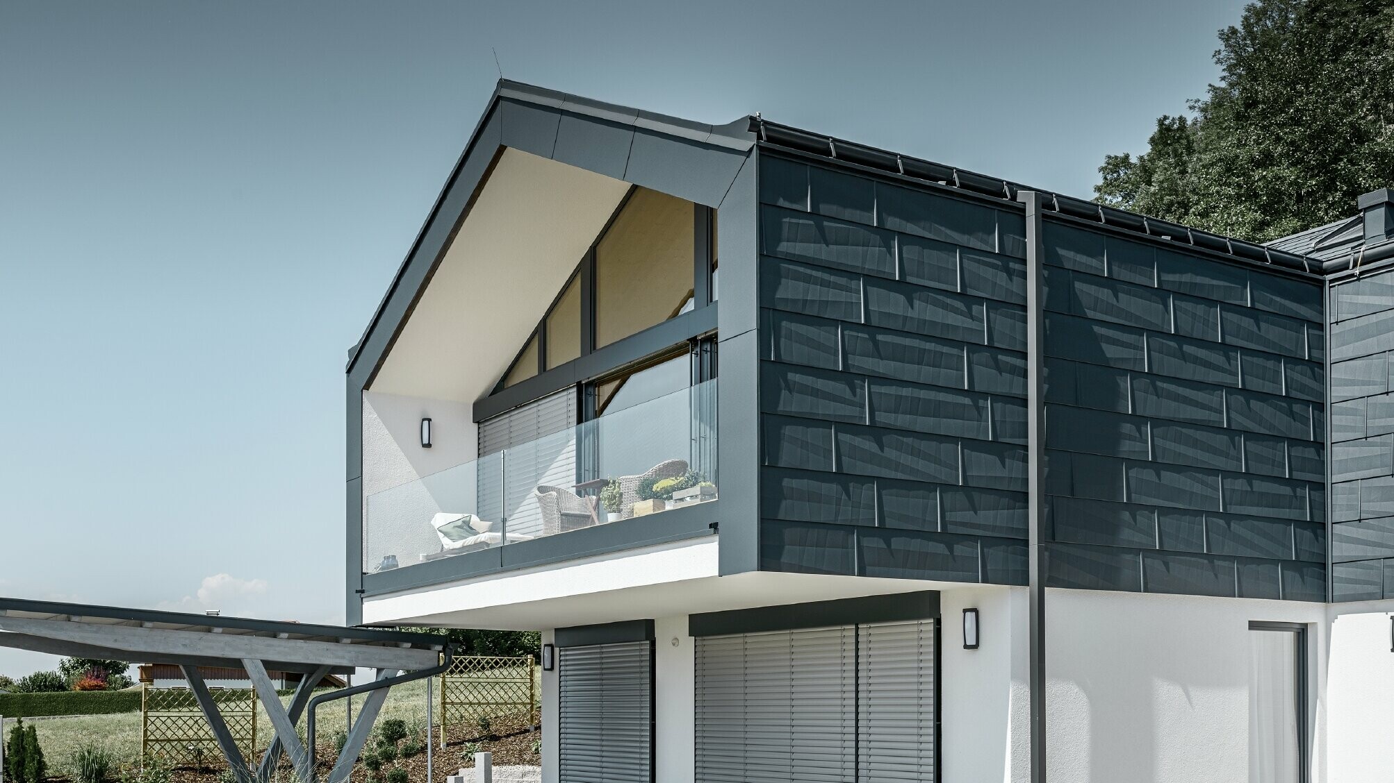 Moderne meergezinswoning met groot raamoppervlak en antracietkleurige FX.12 dak- en gevelpanelen van PREFA