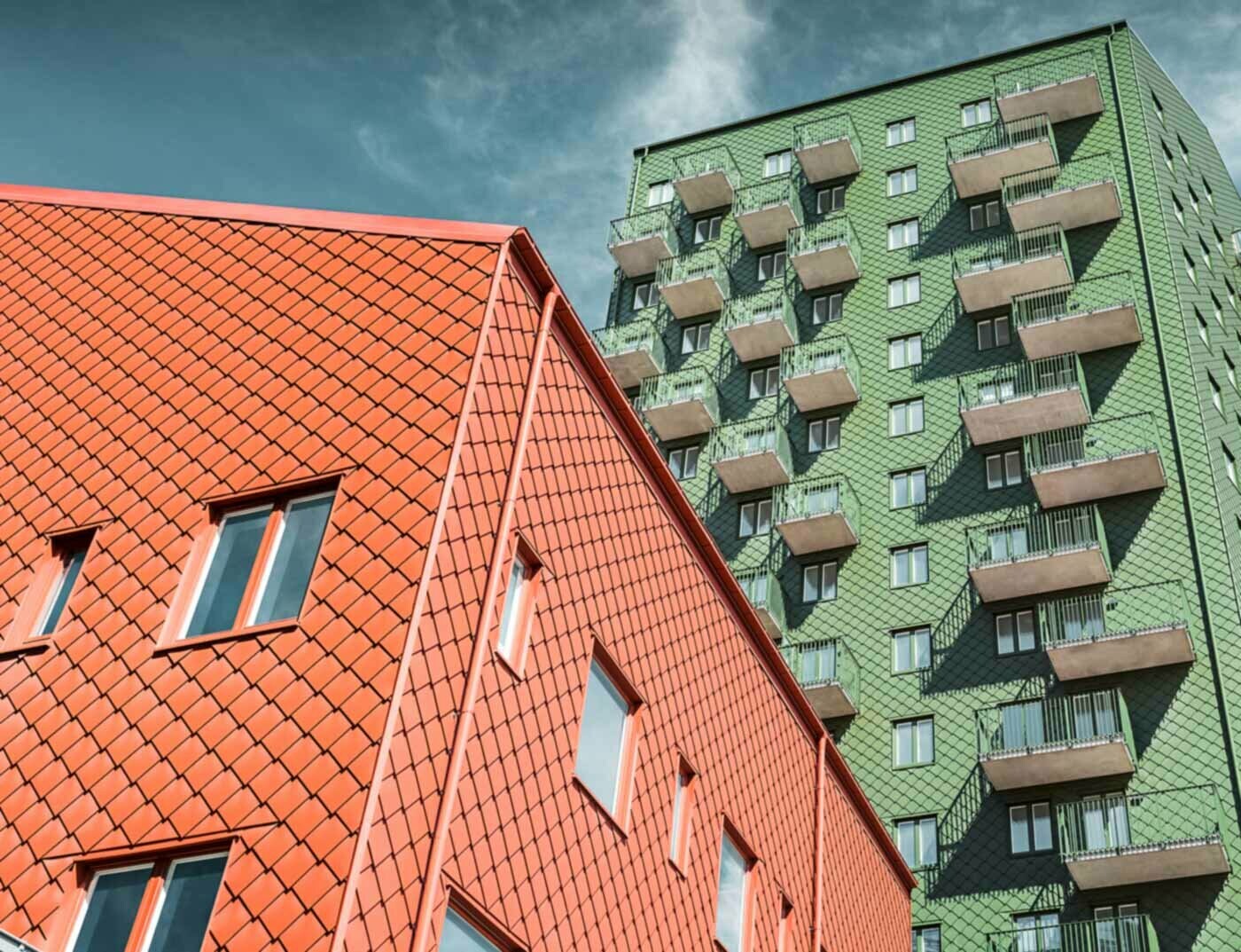 Habitations suédoises avec balcons et losanges de façade PREFA de couleur vert et rouge tuile.