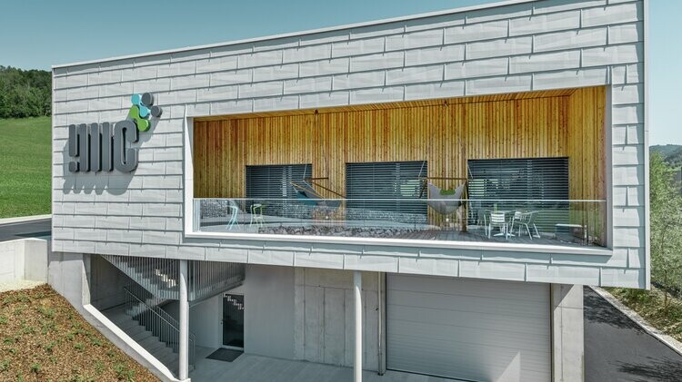 Bedrijfsgebouw in Ybbsitz met plat dak en aluminium gevel van PREFA die voor het gebouw hangt, uitgevoerd in het gevelpaneel FX.12 in prefawit;