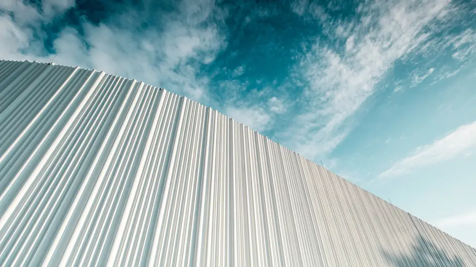 Une architecture à couper le souffle avec une façade en aluminium PREFA blanche dans le parc d’activités Walter Business Park près de Vienne. La façade, composée de profils extrudés sur mesure, crée grâce à son caractère ondulant et fluide un jeu fascinant d’ombre et de lumière. Trois formes de profils différentes apportent une profondeur exceptionnelle et confèrent au bâtiment une esthétique à la fois claire sur le plan stylistique et résolument dynamique. La surface PREFA, durable et résistante aux intempéries, associe une esthétique moderne à une perfection fonctionnelle – un véritable point fort de l’architecture de façade contemporaine, qui rend visibles la qualité architecturale et la sophistication technique.