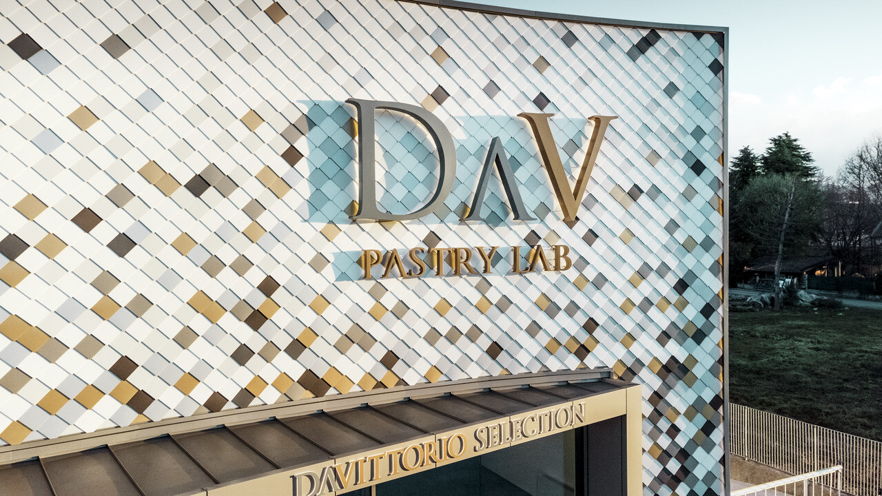 Bedrijfsgebouw van DAV Pastry Lab in Bergamo met gespikkelde losangegevel in de kleuren P.10 bruin, brons, P.10 donkergrijs, mayagoud, blank naturel, P.10 prefawit en P.10 zuiver wit 