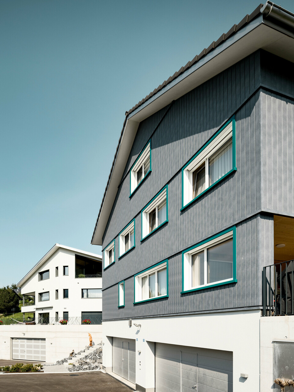 PREFA Sidings in P.10 Steingrau bzw. P.10 Prefaweiß an den Fassaden von zwei benachbarten Mehrfamilienhäusern in Weissbad, Schweiz.