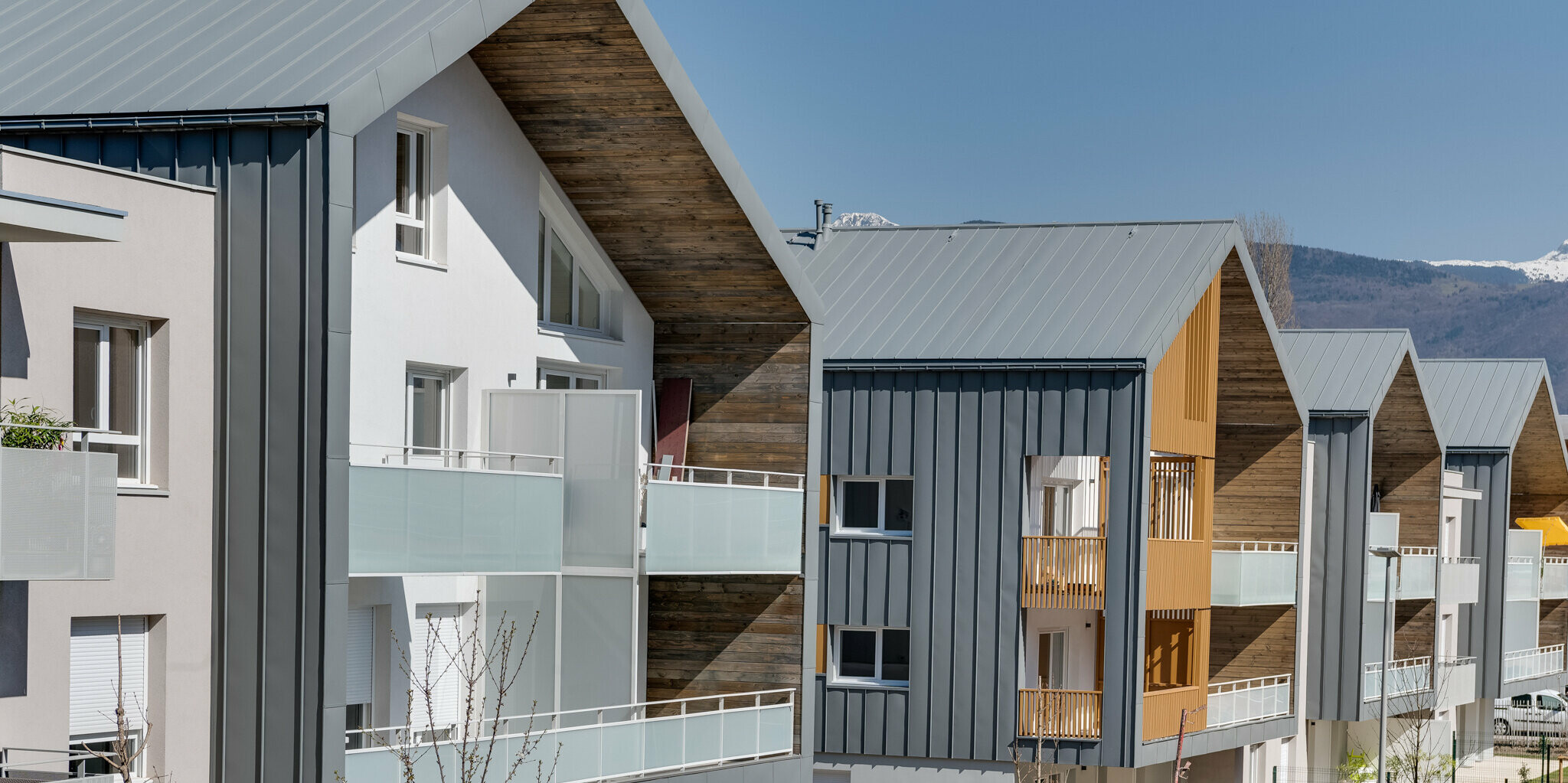 La Résidence L'Athéna se compose de plusieurs parties du bâtiment qui ont été revêtues de PREFALZ en P.10 gris souris. Le complexe résidentiel a été construit par ARCANE Architectes à Varces-Allières-et-Risset, France.