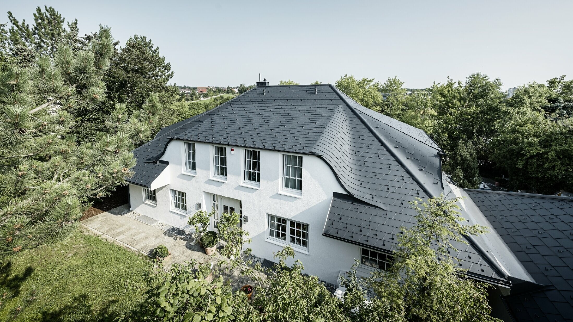 Toit en croupe avec de nombreuses lucarnes arrondies, recouvert des bardeaux de toiture DS.19 en anthracite