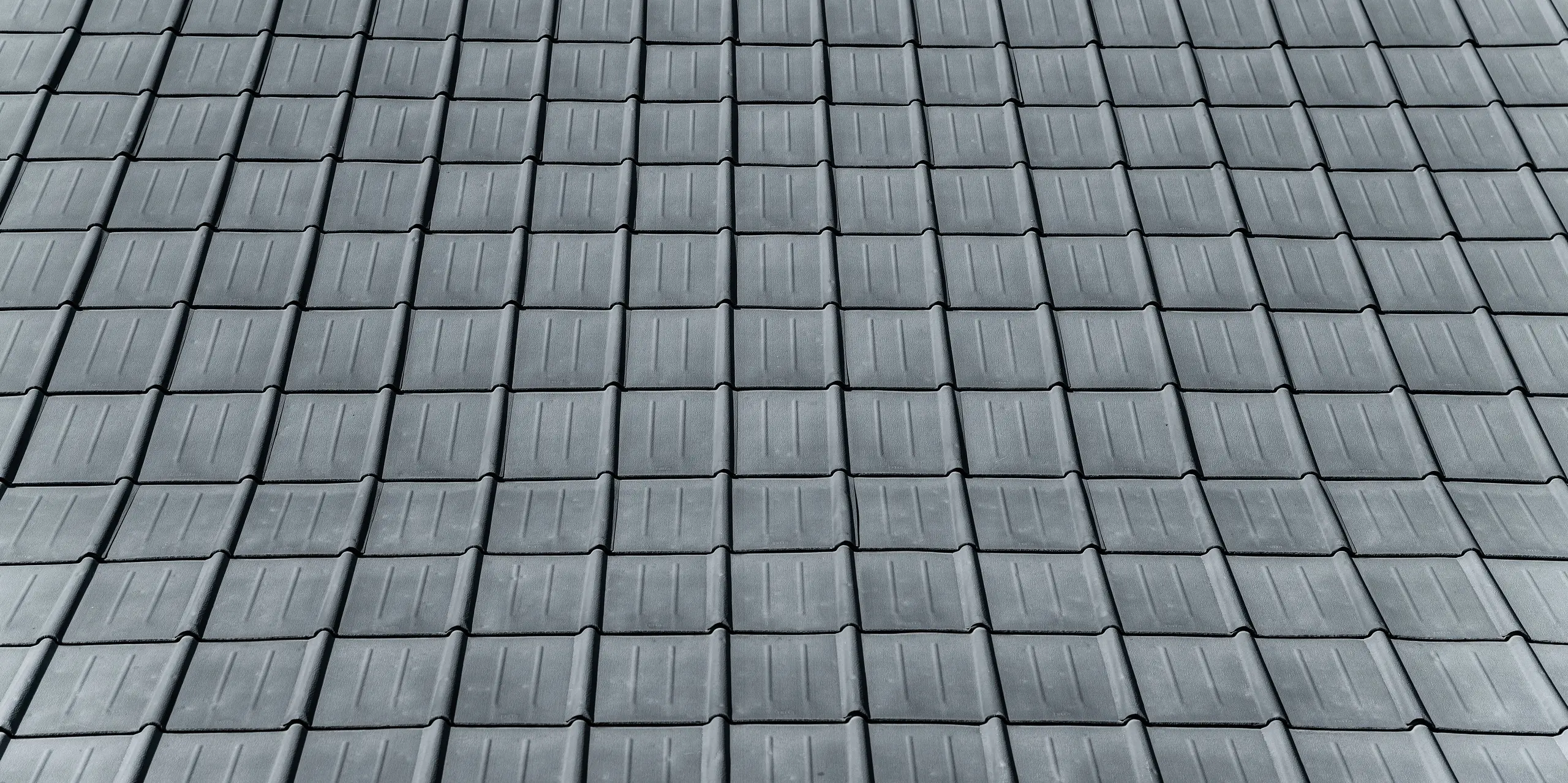 Vue détaillée de la maison individuelle recouverte de tuiles PREFA robustes à Tarvisio, Italie. La photo montre le toit en aluminium durable, qui résiste de manière fiable aux conditions météorologiques alpines depuis 1972 et impressionne par son design intemporel.