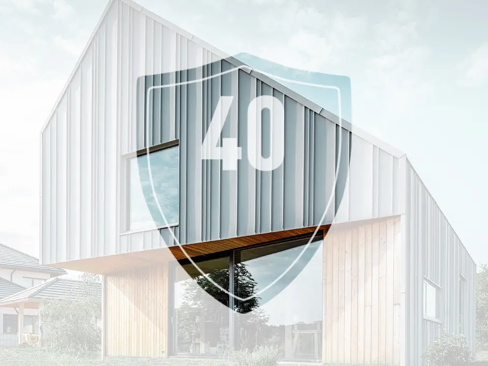 De foto toont een bord met het getal “40”, dat de garantie op PREFA aluminium producten moet voorstellen, voor een modern vrijstaand huis.
