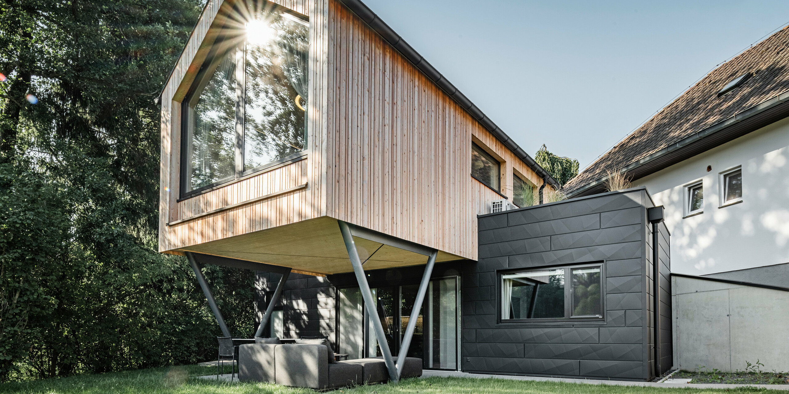 Frontansicht auf das Chalet 5: Fassade des Erdgeschosses mit Siding.X in P.10 Anthrazit verkleidet