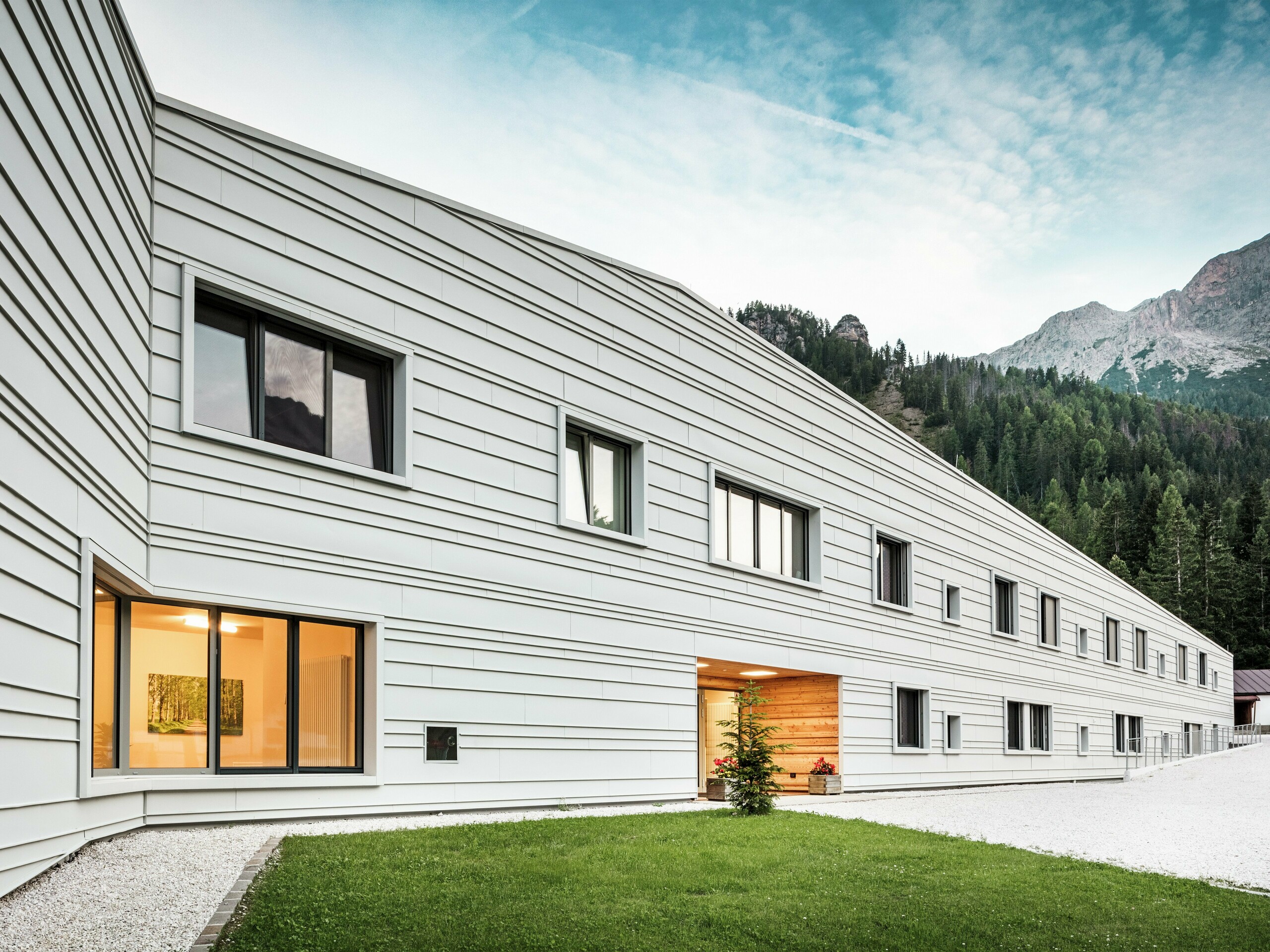 La caserne moderne « Tempesti » dans le Tyrol du Sud séduit par la conception claire de sa façade en PREFALZ P.10 dans la couleur blanc Prefa. Les lames d'aluminium posées horizontalement et à intervalles irréguliers allongent visuellement le bâtiment. La façade claire en aluminium reflète la lumière du soleil et assure ainsi un microclimat amélioré. Cette caserne moderne est une véritable déclaration architecturale au cœur de la nature alpine.