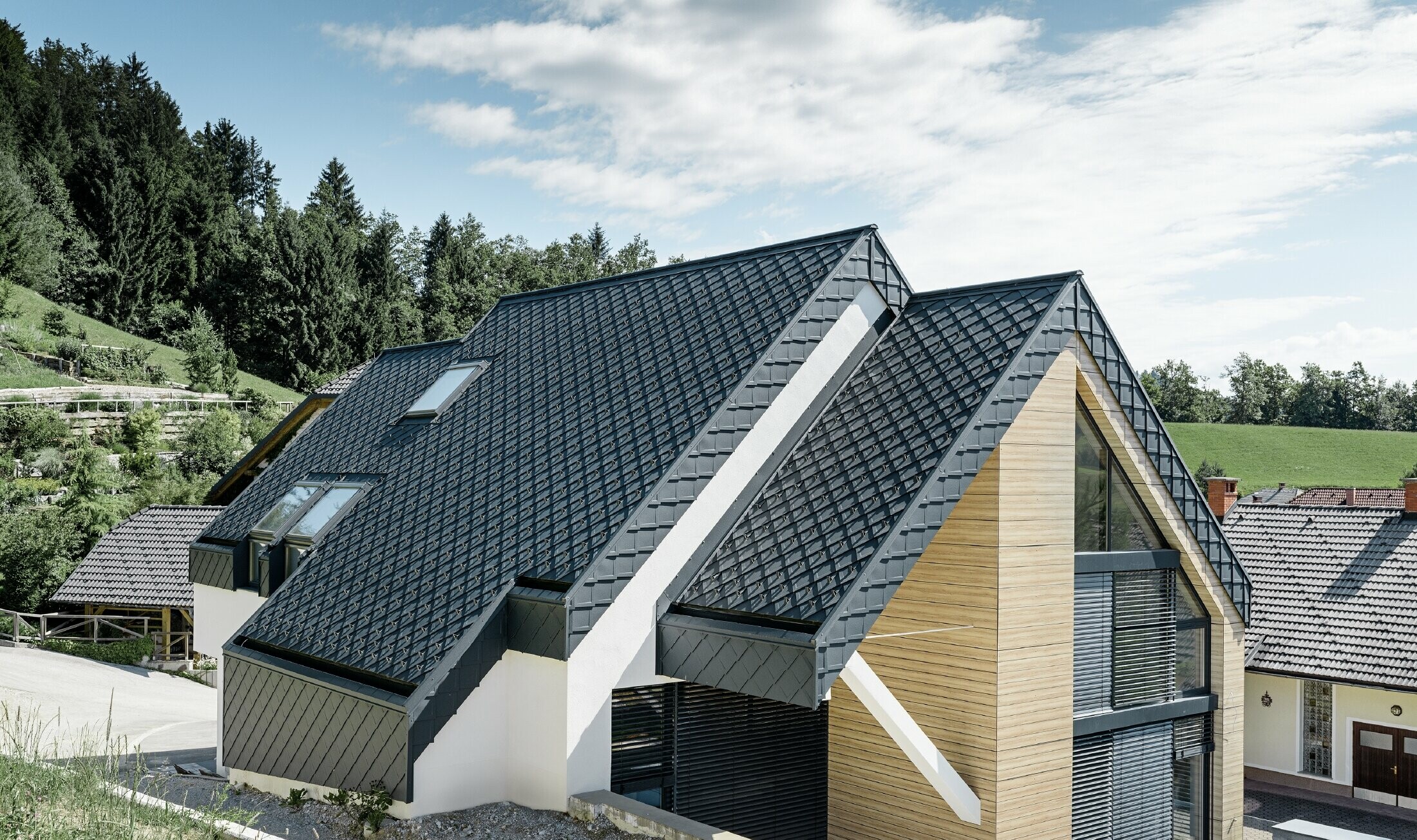 Einfamilienhaus mit Satteldach ohne Dachvorsprung mit einer Fassade in Holzoptik und einem Aluminiumdach in anthrazit