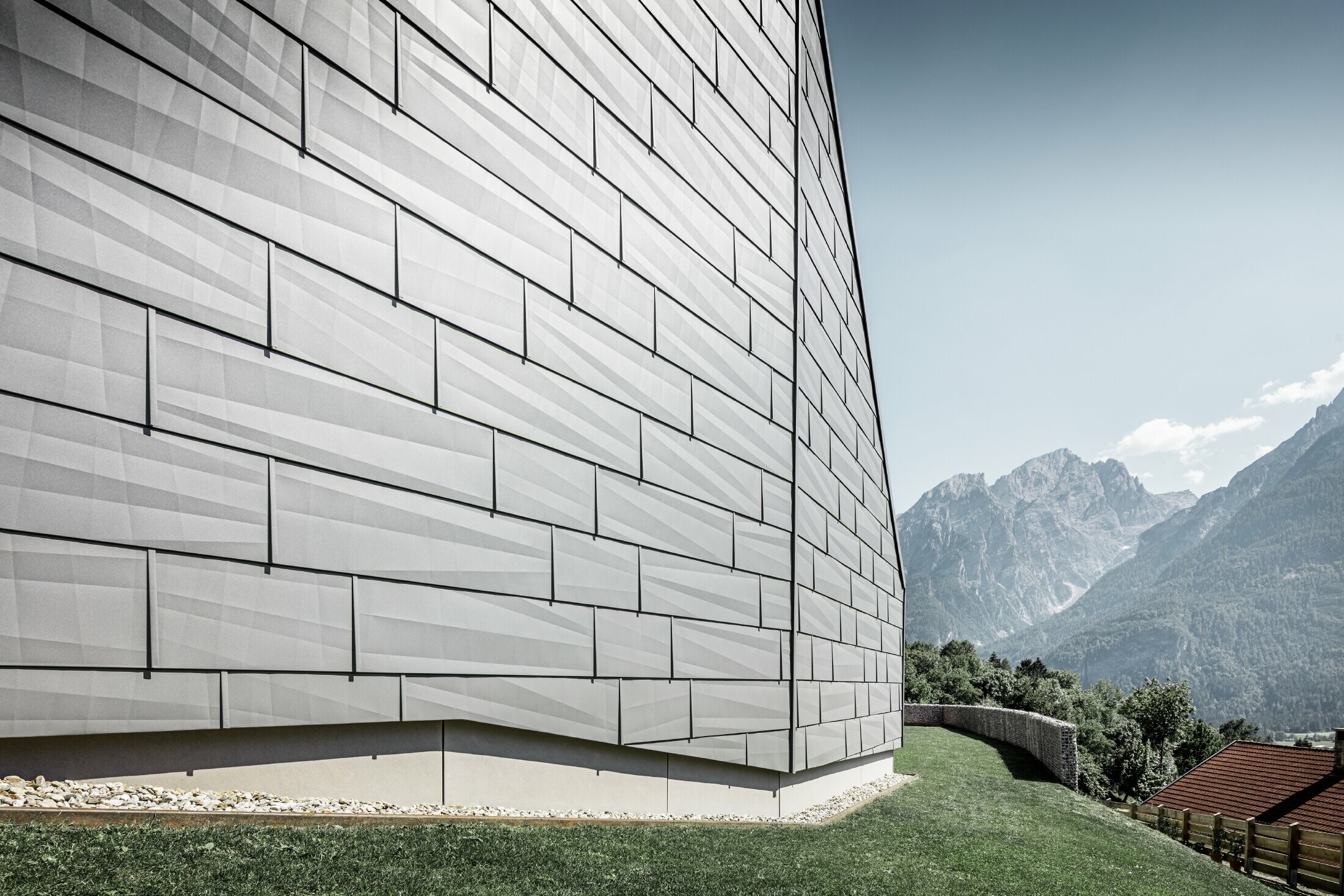 Le côté exposé aux intempéries de la maison individuelle à Lienz, en Autriche, a été recouvert de panneaux de façade FX.12 PREFA en P.10 gris souris.