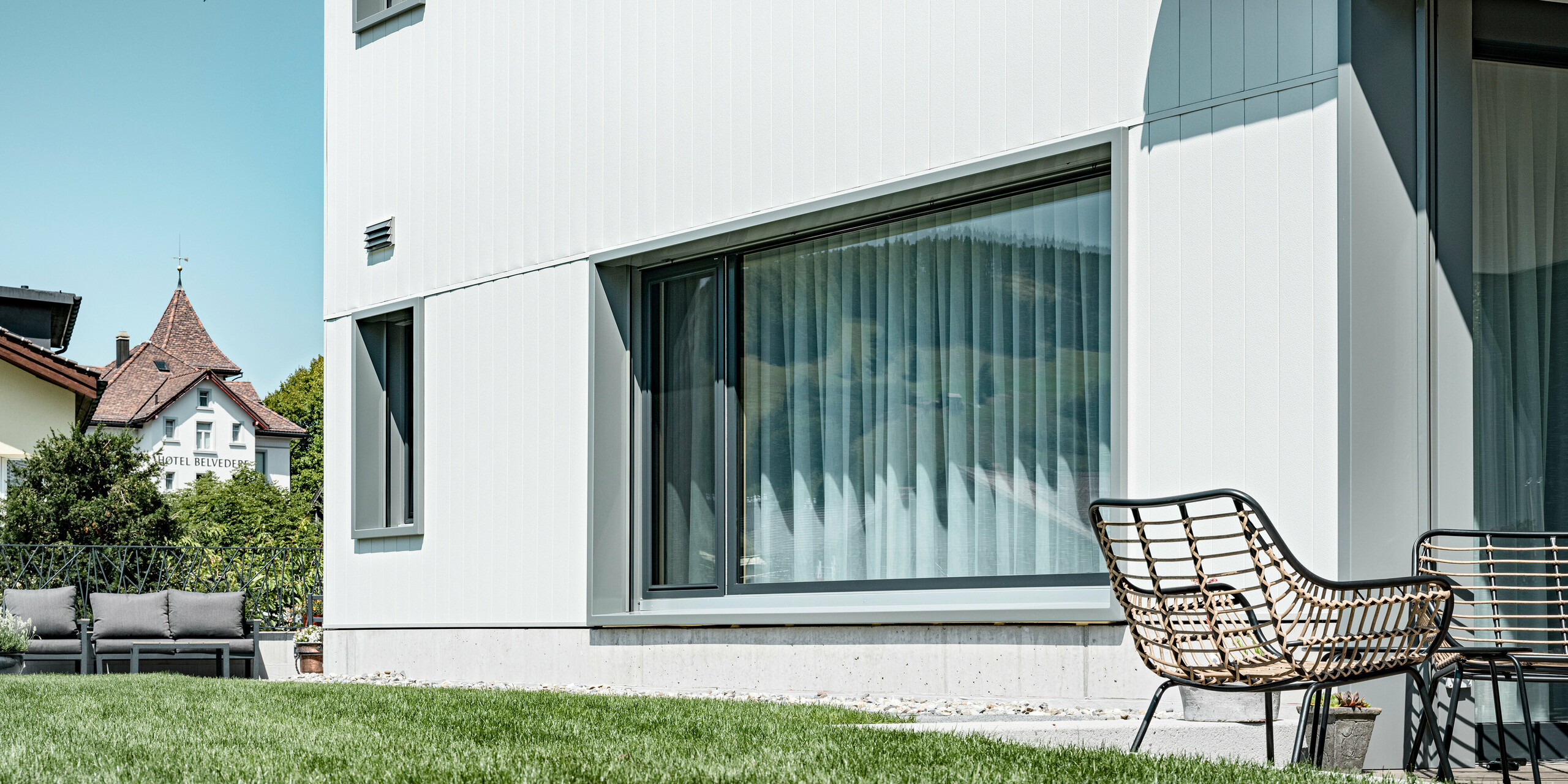 Sidings PREFA en gris pierre P.10 et blanc Prefa P.10 sur les façades de deux immeubles d'habitation voisins à Weissbad, en Suisse.