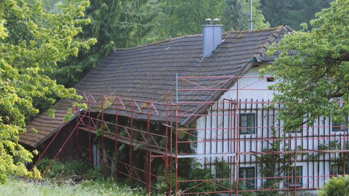 Ancienne toiture de la maison traditionnelle « Wiesenhaus » peu avant sa rénovation avec des bardeaux PREFA (échafaudage en place)