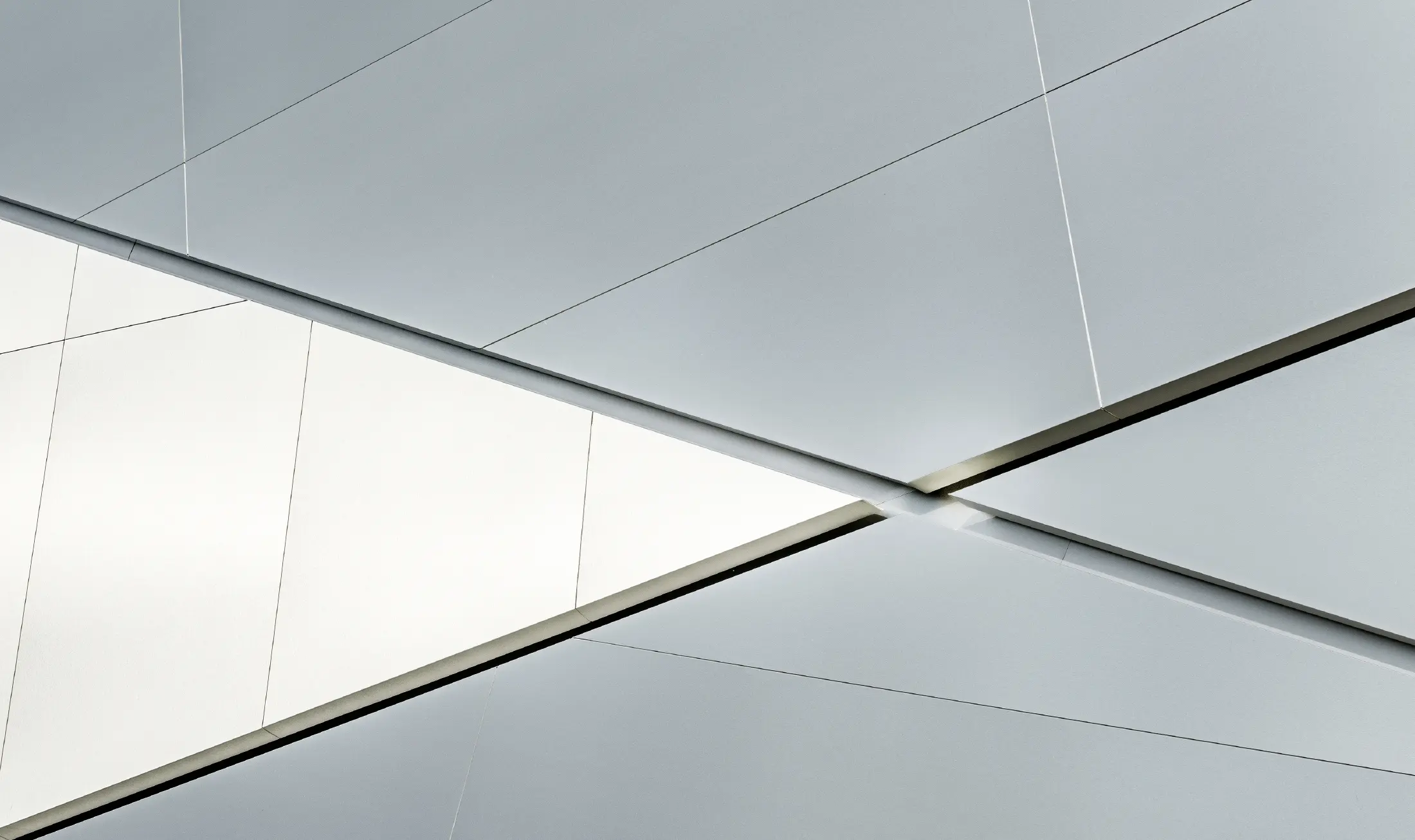 Bedrijfsgebouw (Fill) met futuristische gevel met composietplaten in geborsteld aluminium en achtergrondverlichting in de voegen.