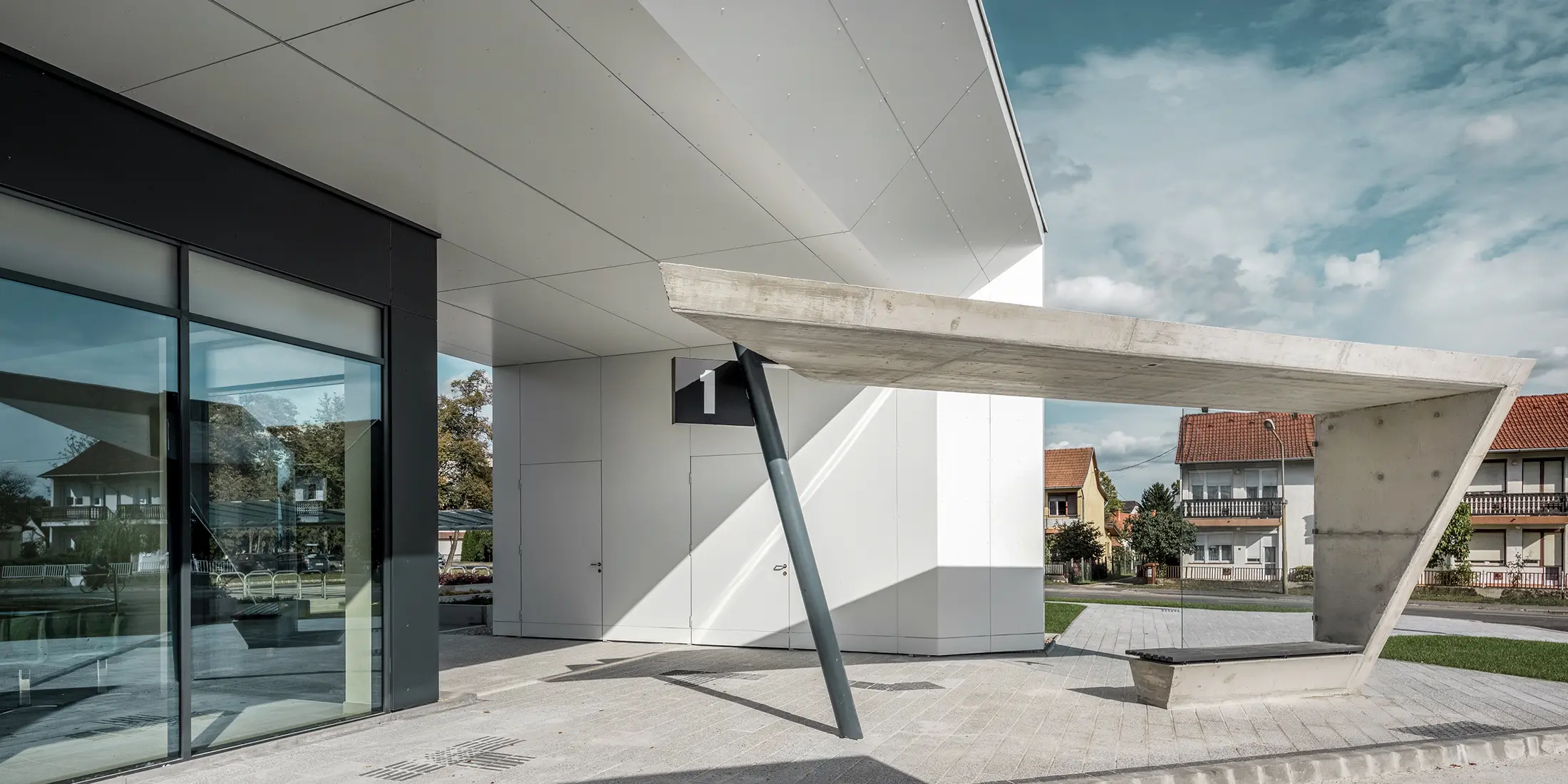 Entree van het busstation Lenti; de onderkant van de overkapping is bekleed met PREFABOND aluminium composietplaat van PREFA in zuiver wit, de gevelelementen bij de toegangsdeuren en etalages zijn bekleed met P.10 antraciet.