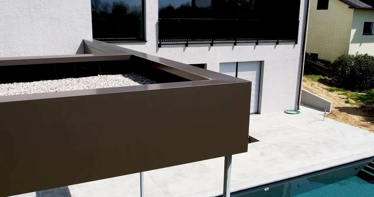 Ansicht der Sonderlösung der Poolüberdachung, wobei die Fassade über die Attika gekantet ist.