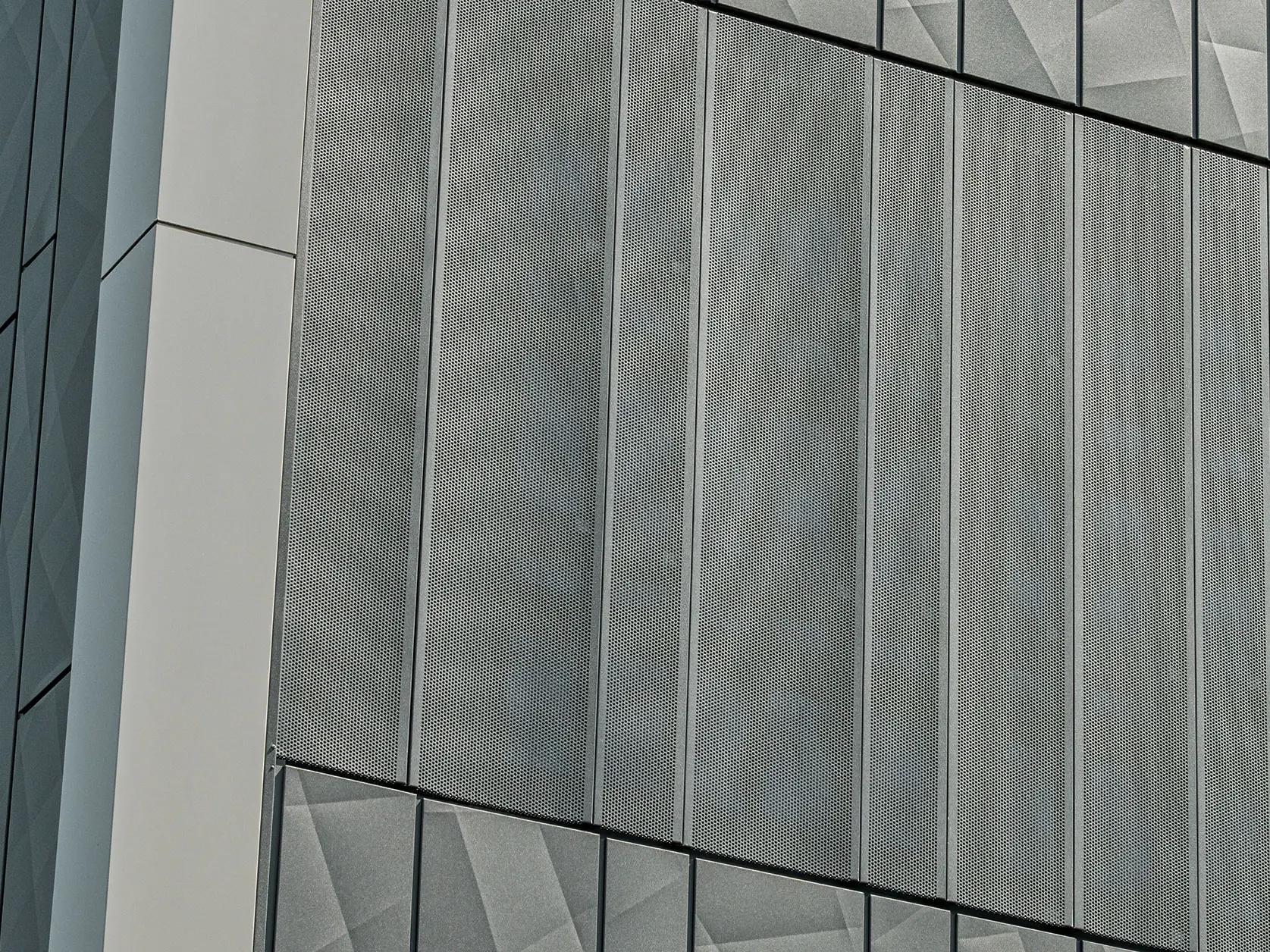 Fassadenansicht eines Eurospar-Markts in Rohrbach mit PREFA Siding.X und perforierten Sidings in der Farbe Anthrazit. Die Siding.X-Elemente zeigen ein lebendiges, geometrisches Fugenbild, während die perforierten Sidings eine moderne, luftdurchlässige Struktur bieten.