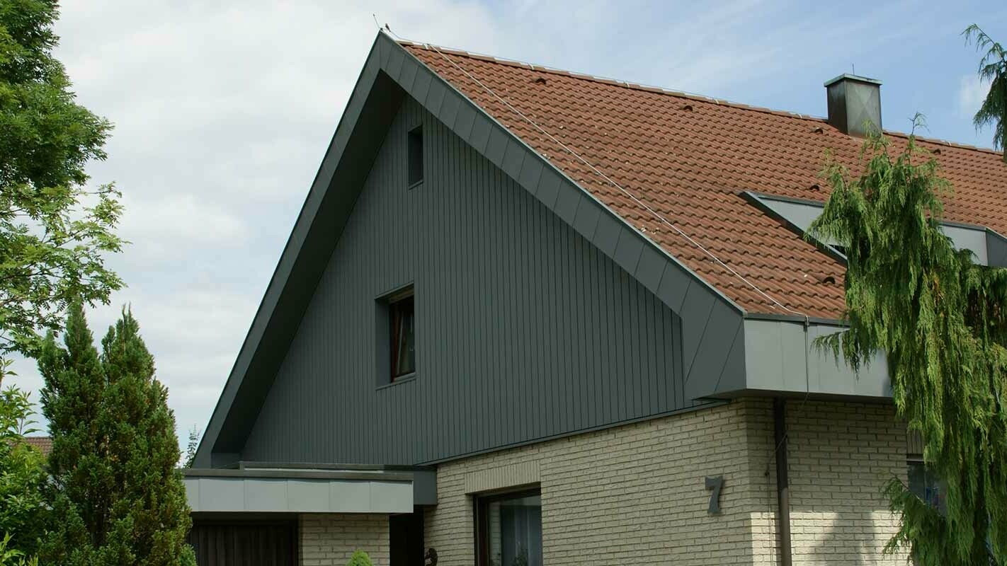 Moderne und witterungsbeständige Giebelverkleidung nach der Sanierung mit PREFA Sidings vertikal verlegt
