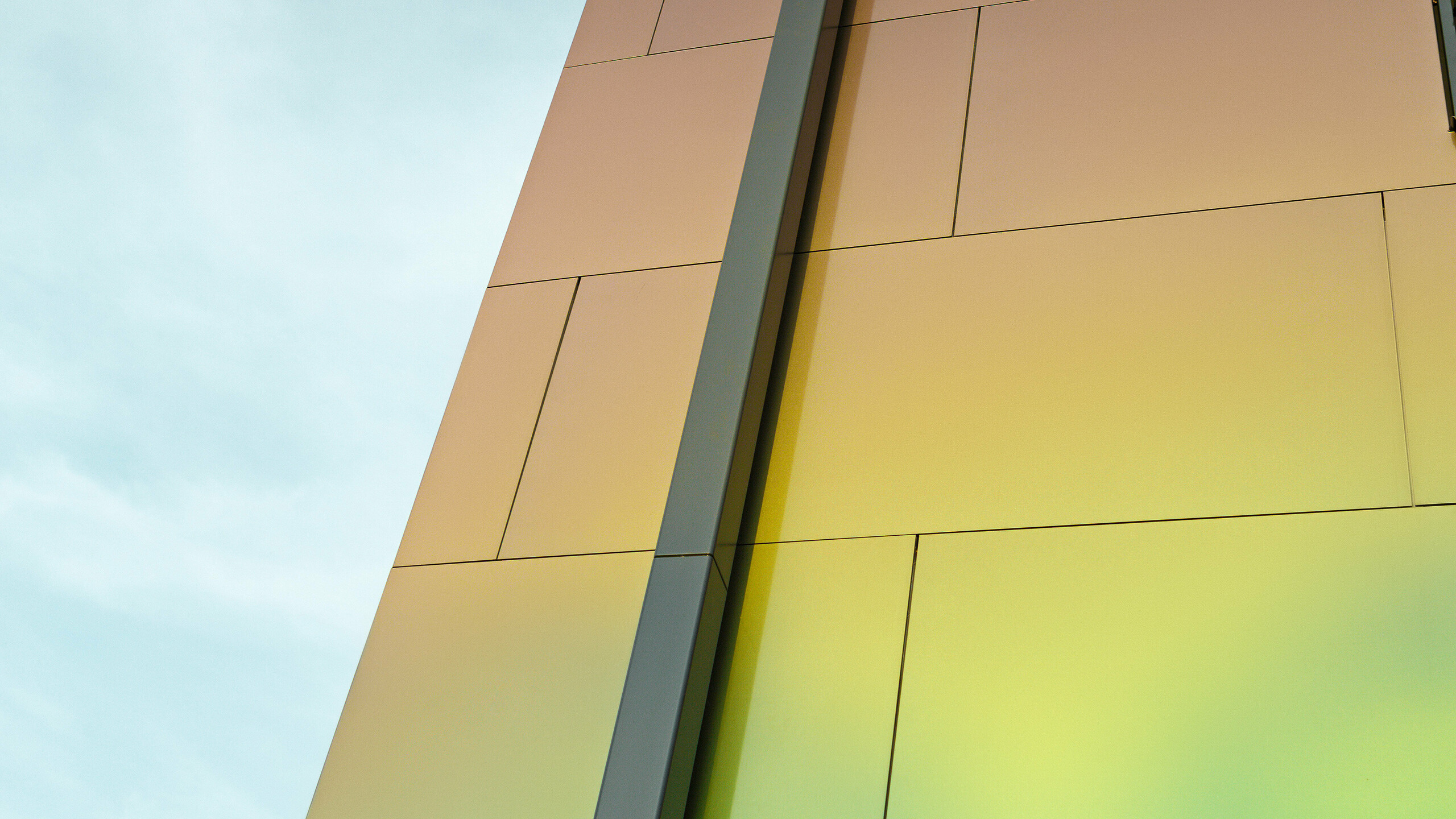 Bordure d'une maison individuelle moderne avec le tuyau de descente carré PREFA moderne pour l'évacuation des eaux pluviales du toit plat. La façade est revêtue d'un panneau composite en aluminium dans la couleur chatoyante « spring lake ».